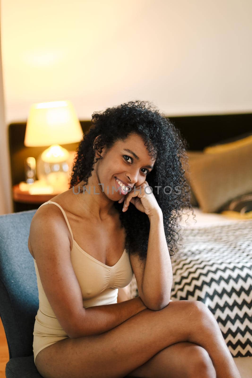 Young afro american girl wearing underwear and sitting in bedroom. by sisterspro