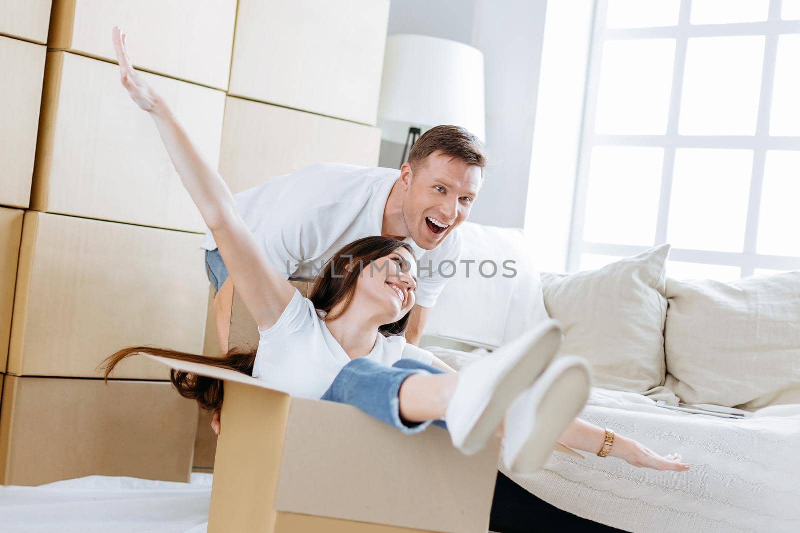 husband and wife have fun unpacking boxes in their new apartment by SmartPhotoLab