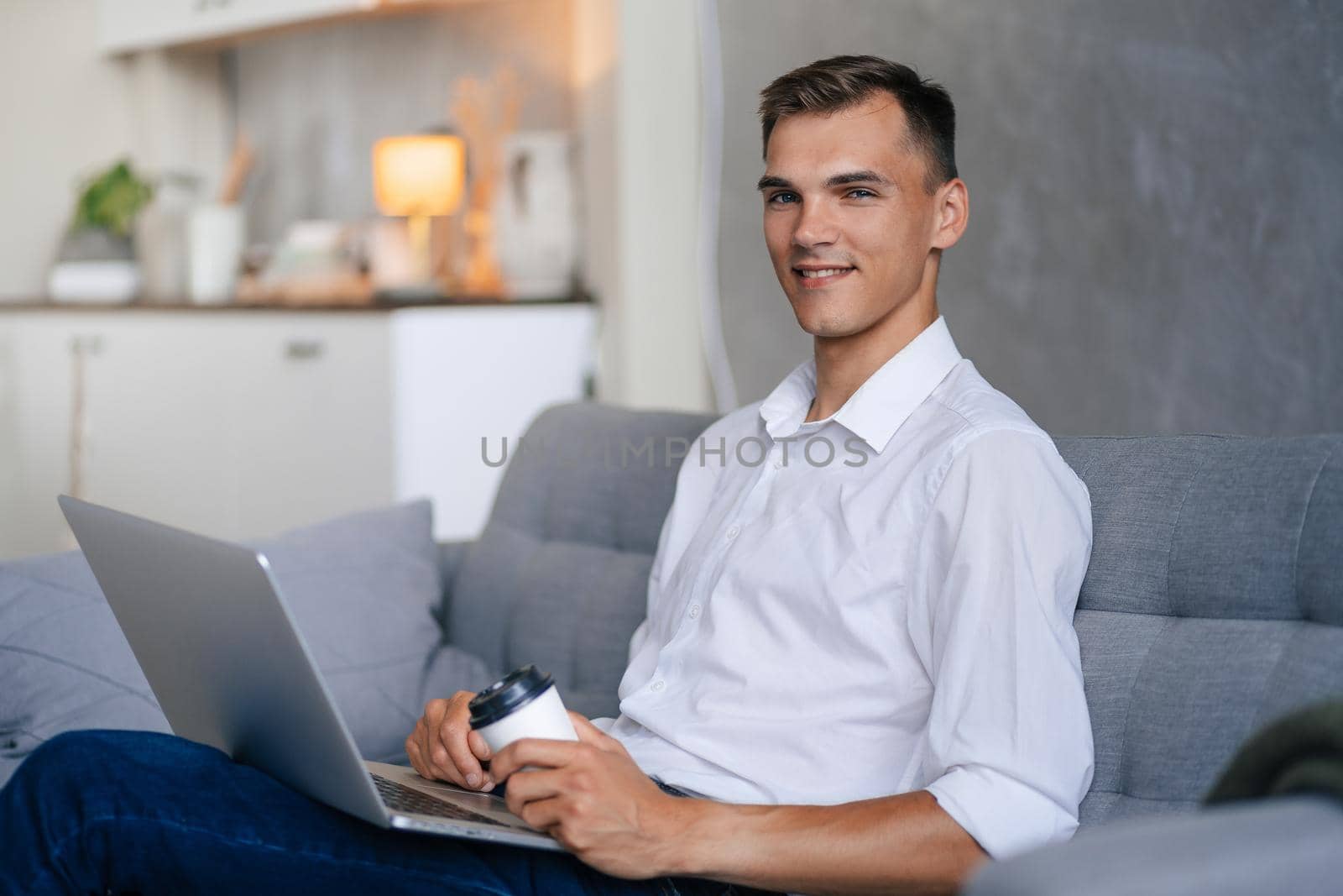 close up. young man with a laptop sitting on the sofa in the living room .