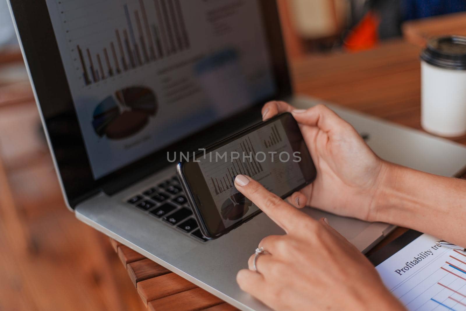 business woman using smartphone to analyze financial data. by SmartPhotoLab