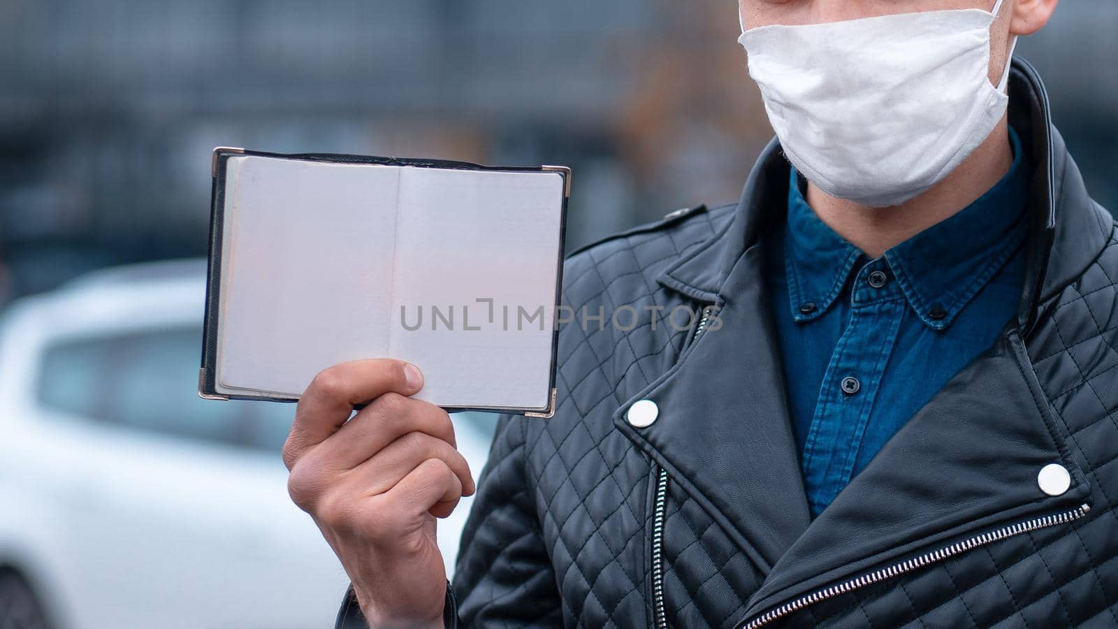 man in protective mask presenting his personal passport. by SmartPhotoLab
