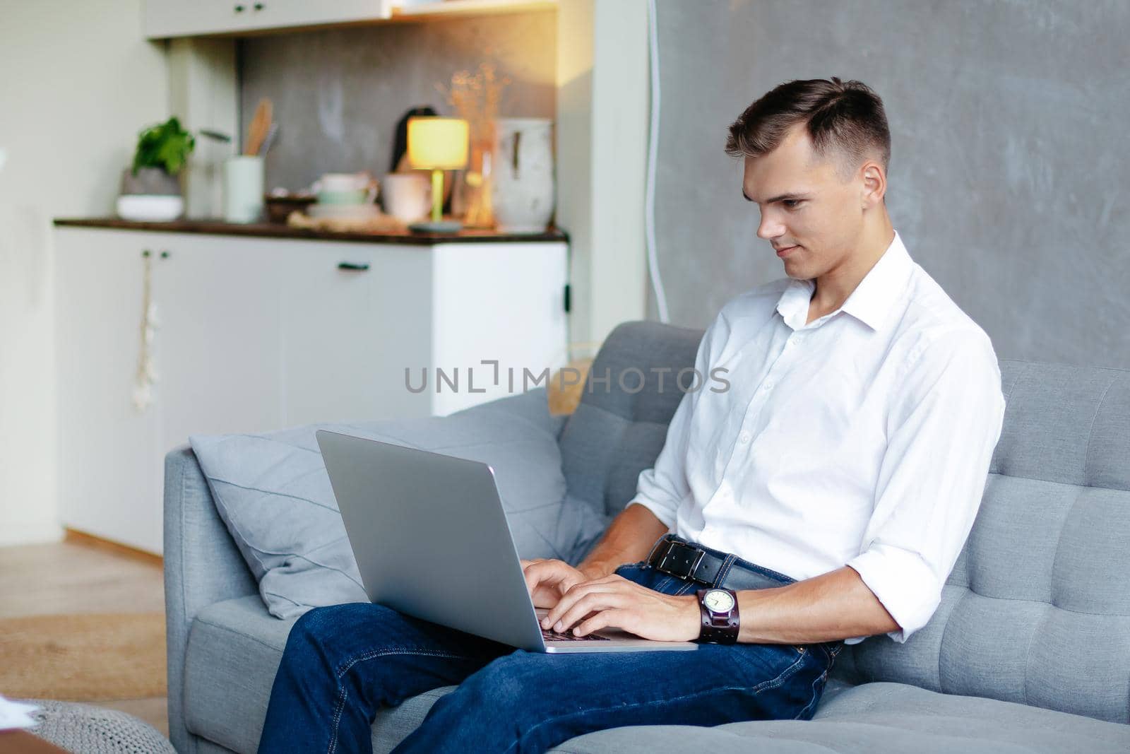 young man is working on a laptop in his apartment . domestic life.