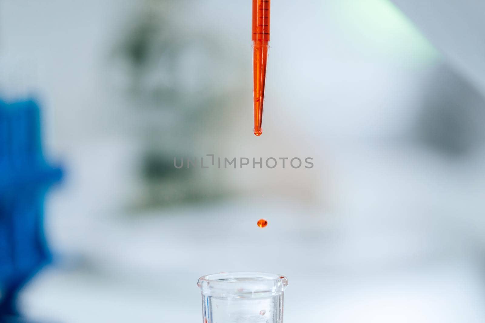 close up. background image of a drop of red liquid in a laboratory pipette. photo with a copy-space.