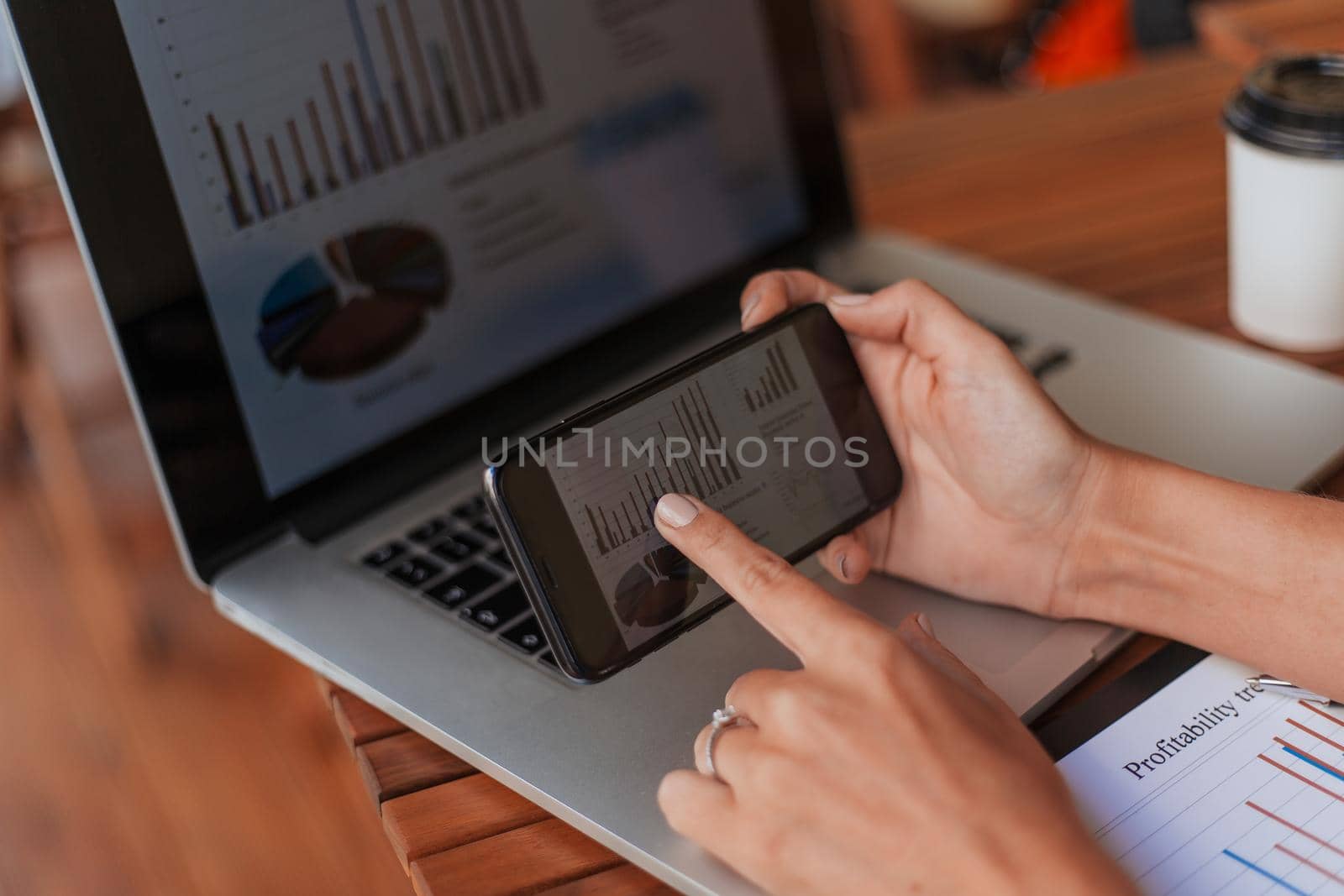 business woman using smartphone to analyze financial data. by SmartPhotoLab