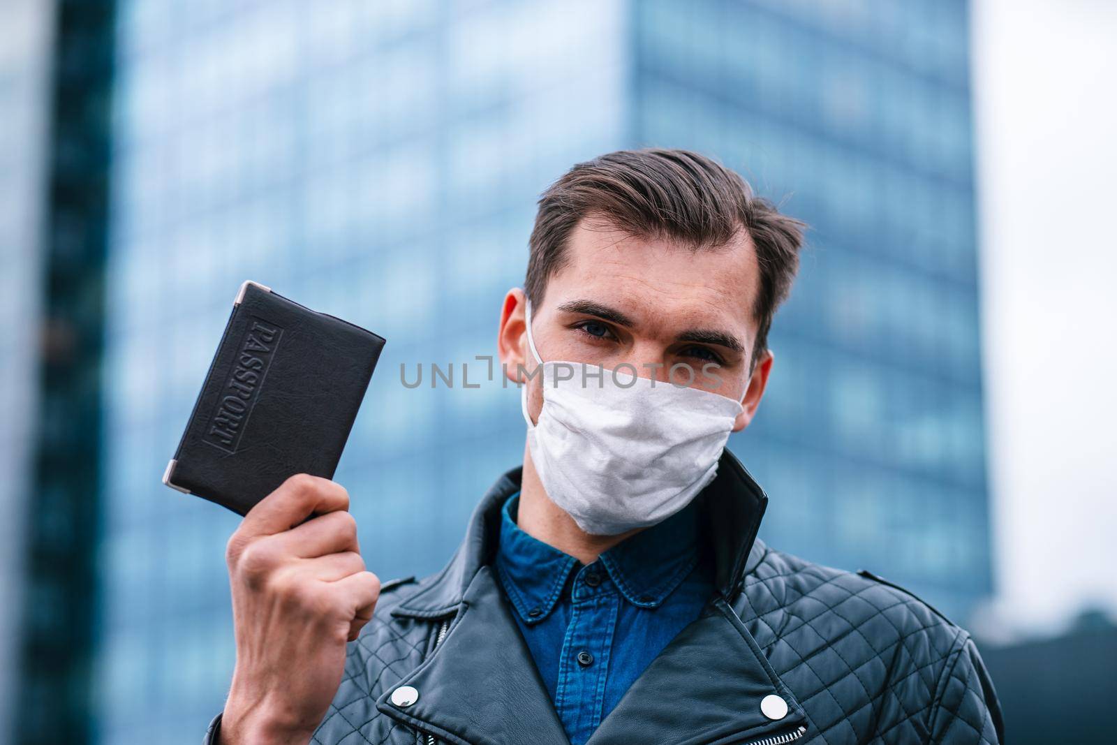 close up. a man in a protective mask showing his passport