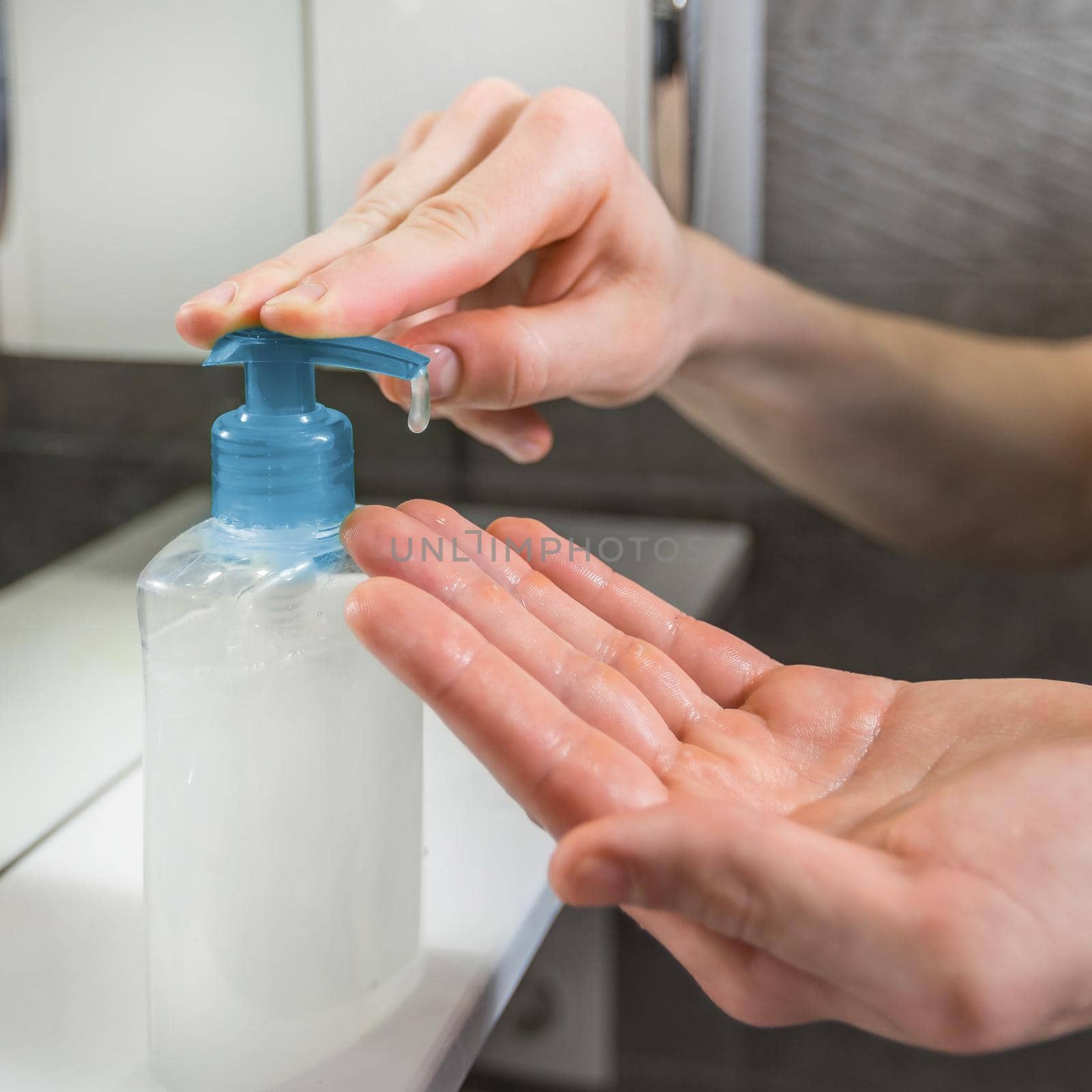 close up. man using a dispenser with bactericidal soap. by SmartPhotoLab