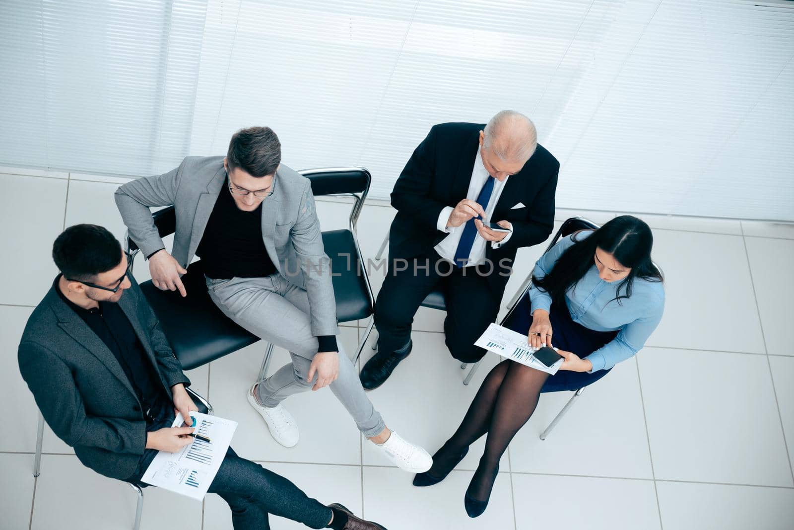 top view. businessman using a smartphone during a work meeting. photo with copy-space