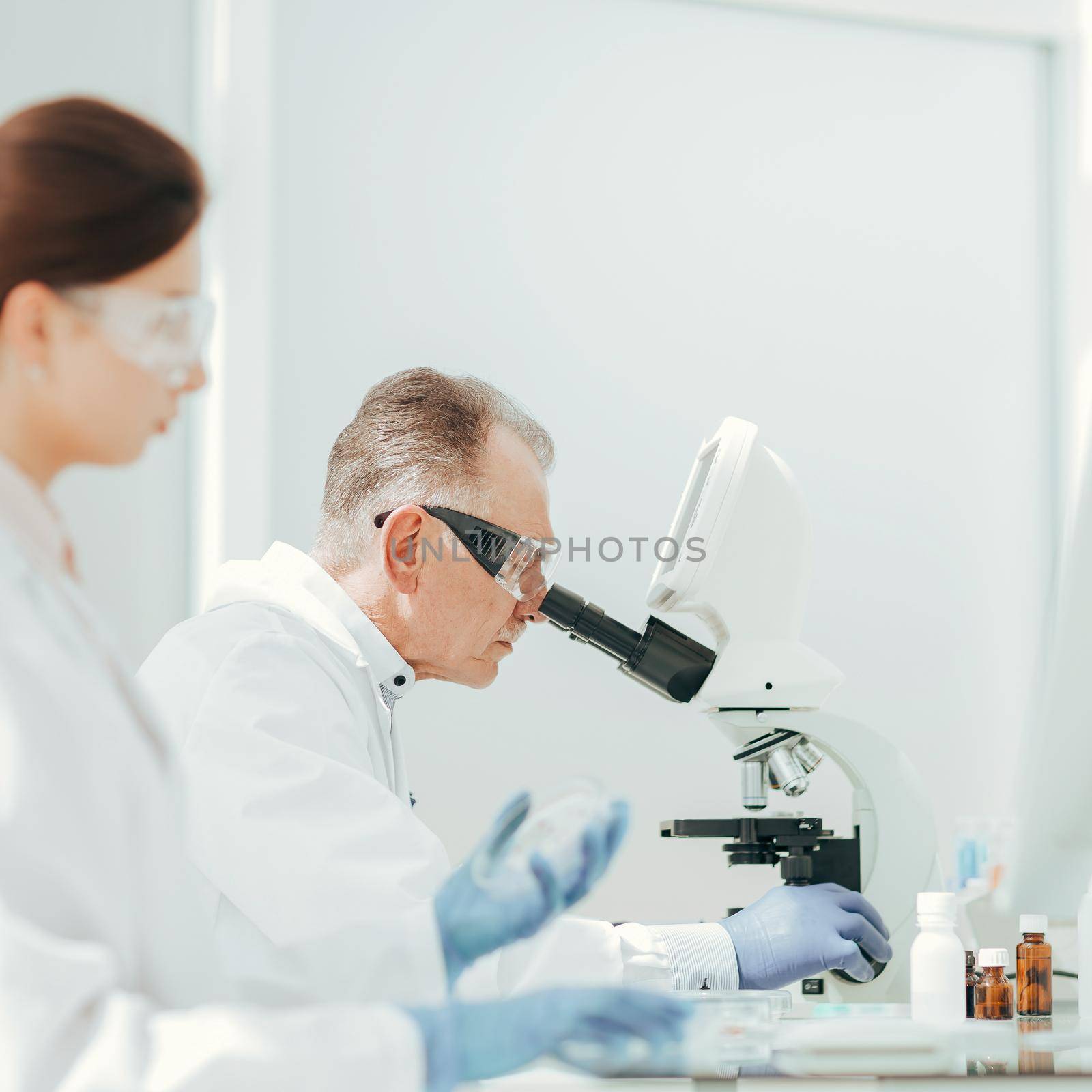 pharmacists from all over using microscope in the laboratory. by SmartPhotoLab