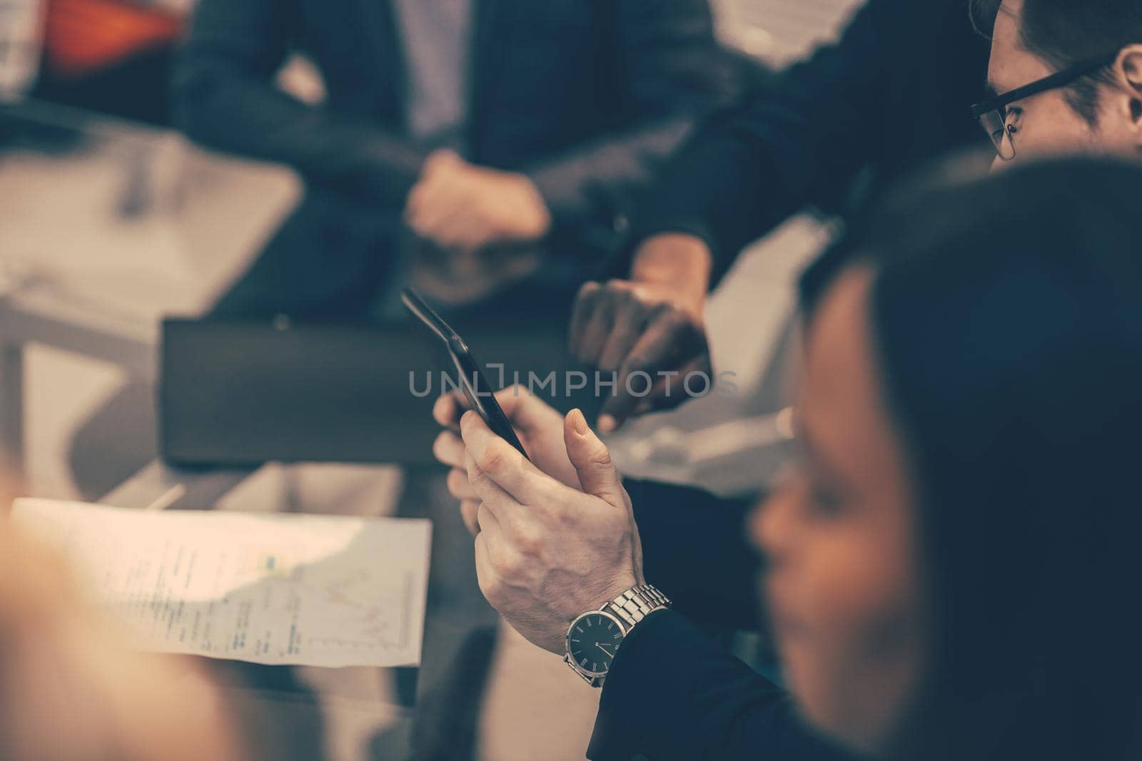close up. employees using their smartphone to view new information. by SmartPhotoLab