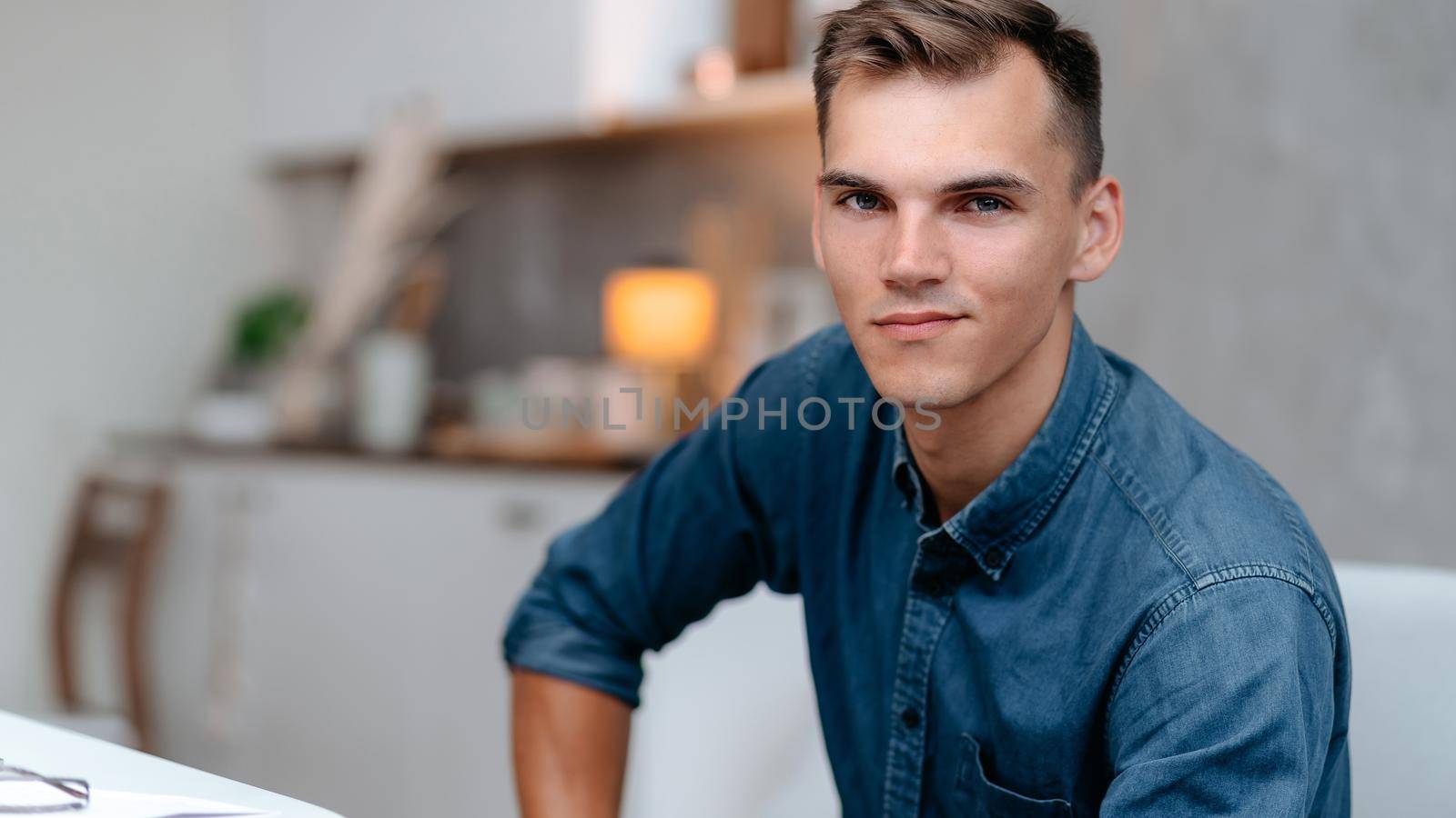 attractive young man sitting in a home chair.