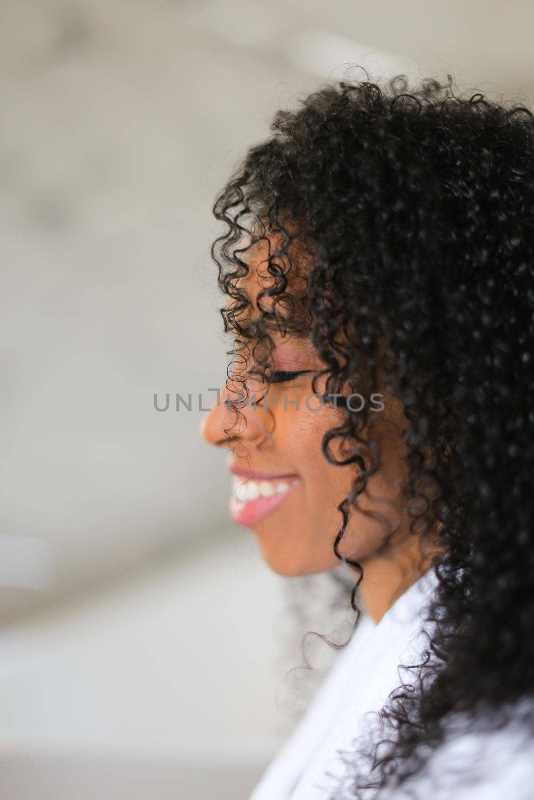 Portrait of smiling afro american curly haired young woman. Concept of african female beauty.