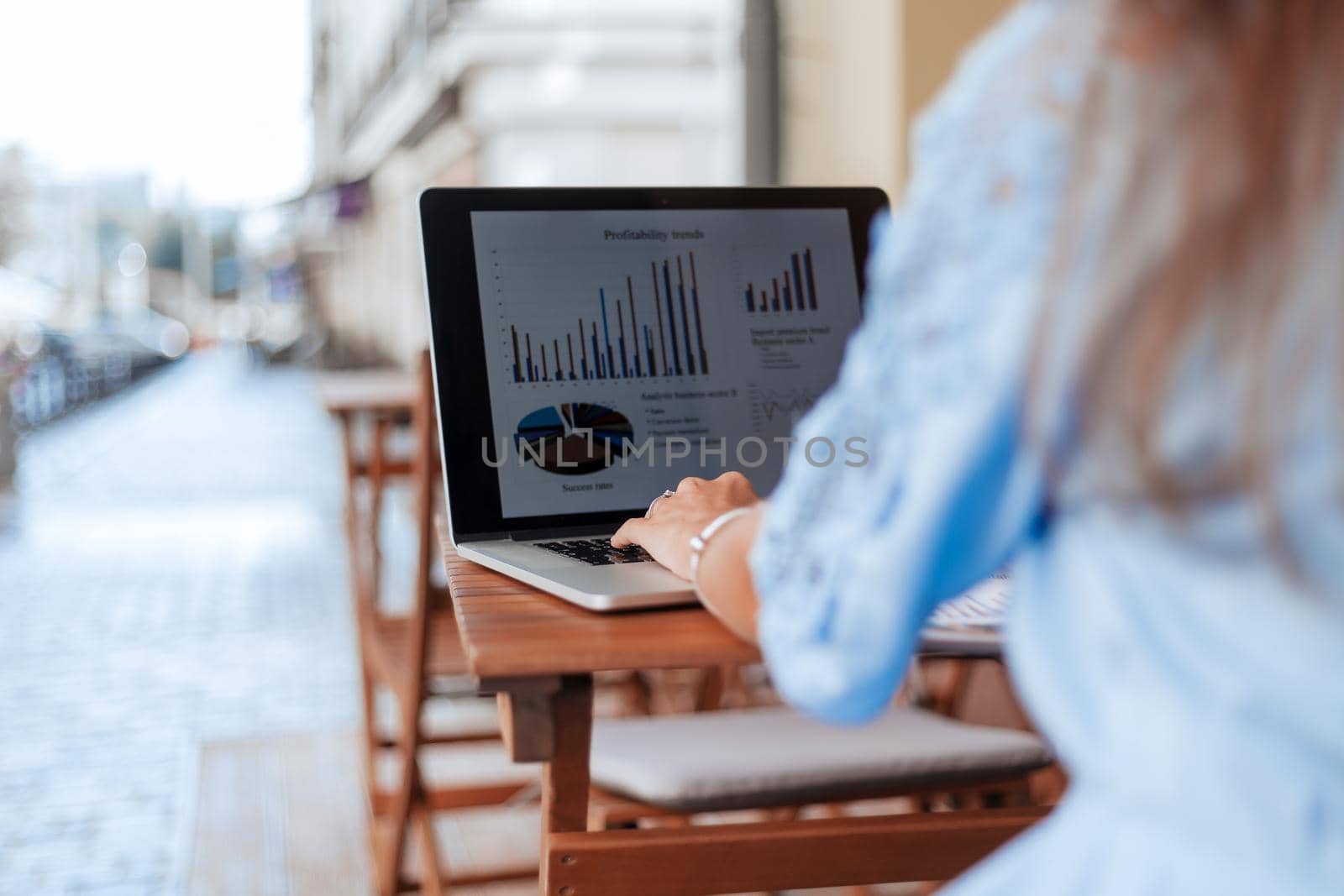 business woman analyzing financial data sitting at a table in a cafe. by SmartPhotoLab