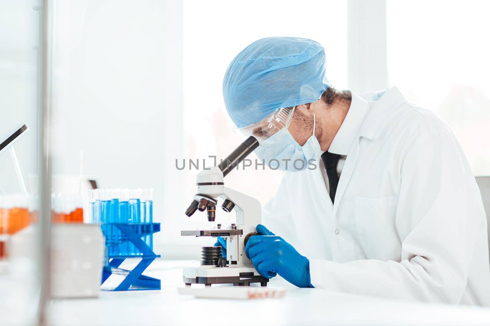 close up. scientist looking into the eyepiece of a microscope. photo with a copy-space.