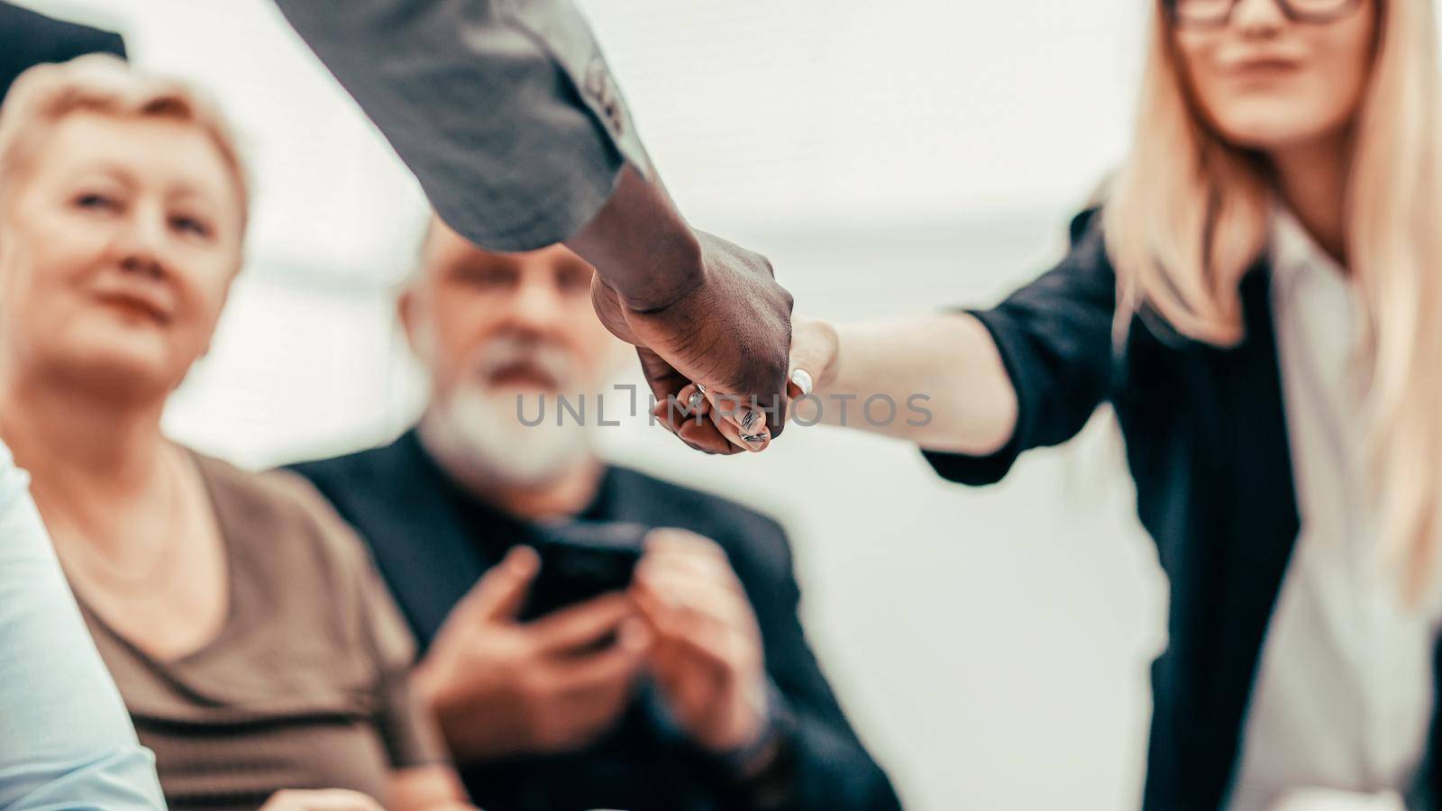businessman and businesswoman shaking hands over the meeting table. business concept