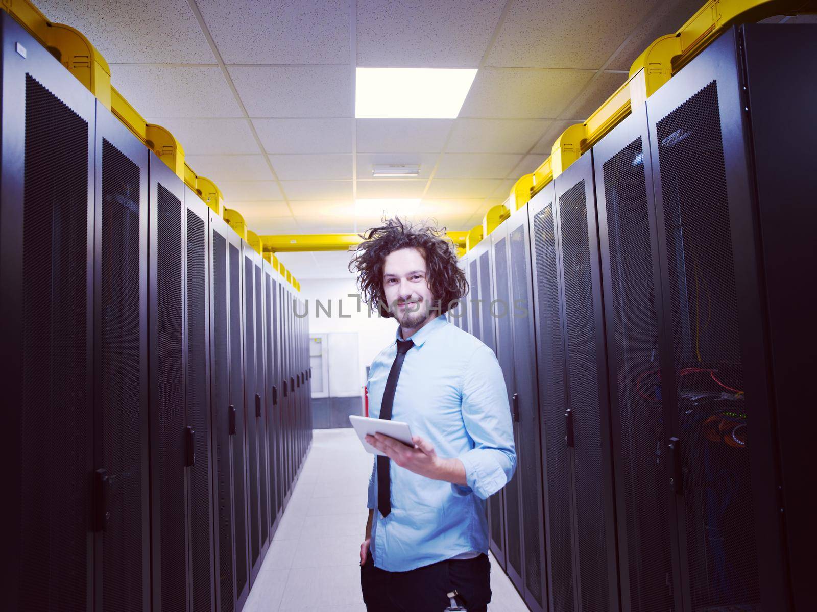 Male IT engineer working on a tablet computer in server room at modern data center