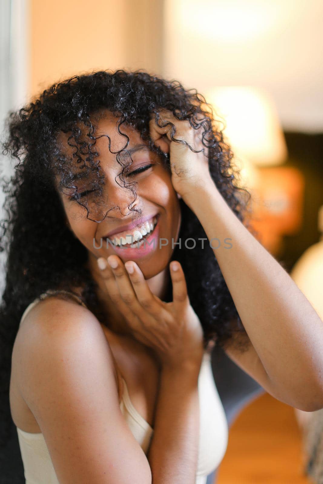 Portrait of beautiful black girl sitting in room and wearing beige lingerie. by sisterspro