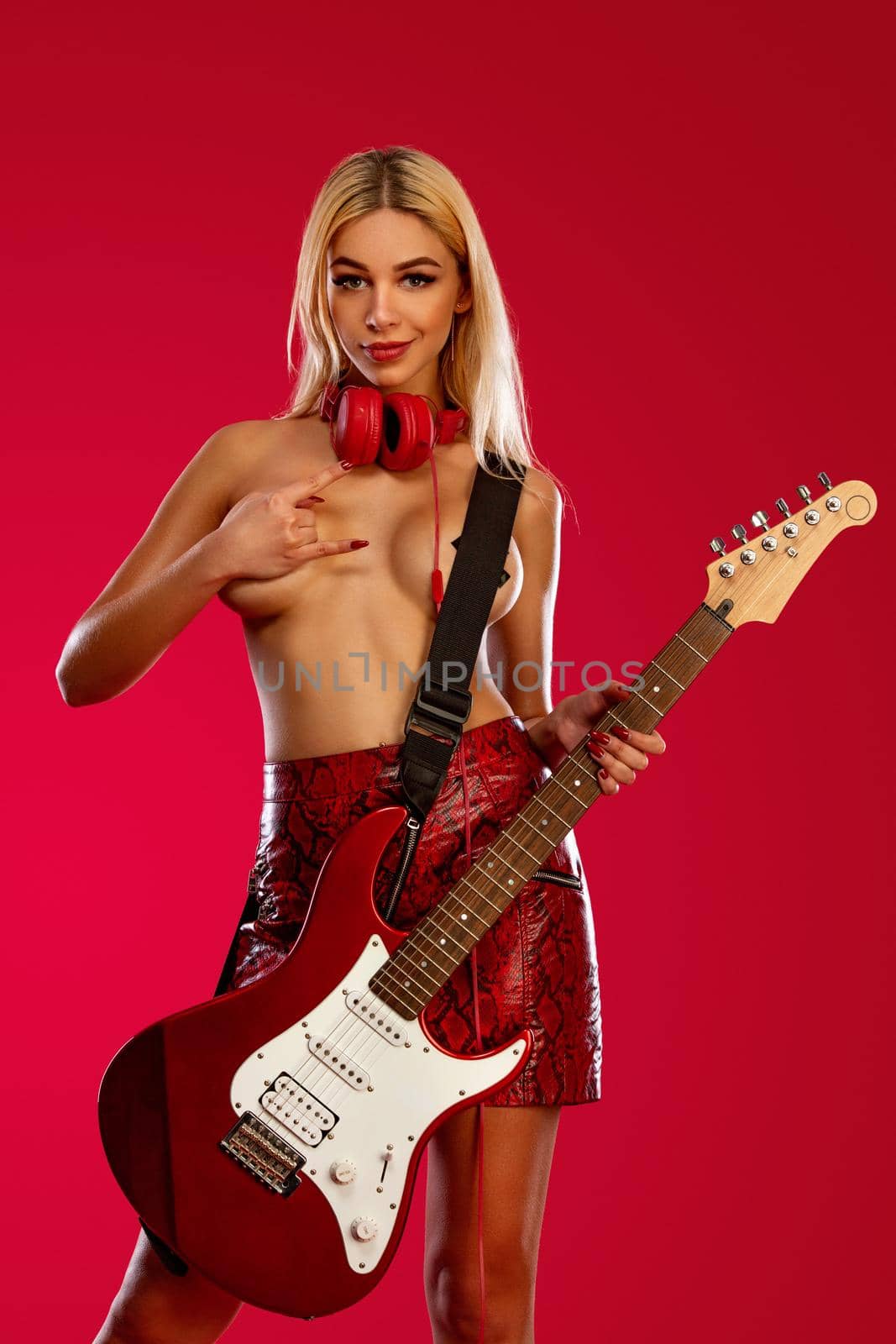Club poster for night party with young sporty and beautiful go-go woman DJ with electric guitar and headphones isolated on red background. by MikeOrlov
