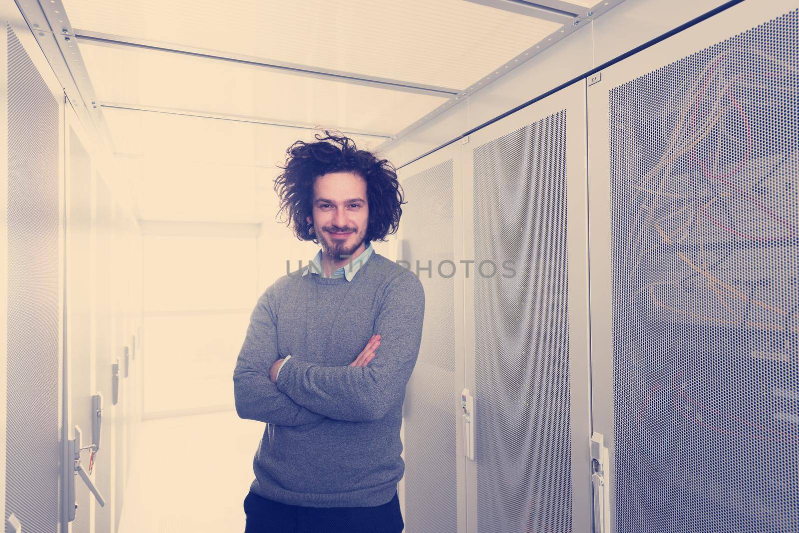 portrait of young handsome IT engeneer in datacenter server room