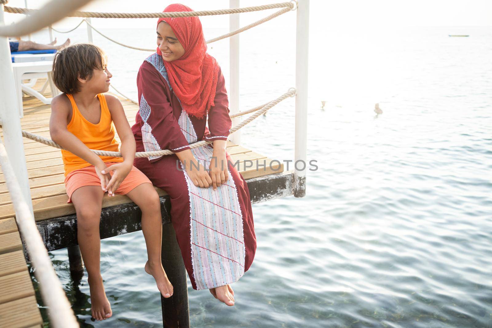 Happy young friends enjoying on pier at sea by Zurijeta