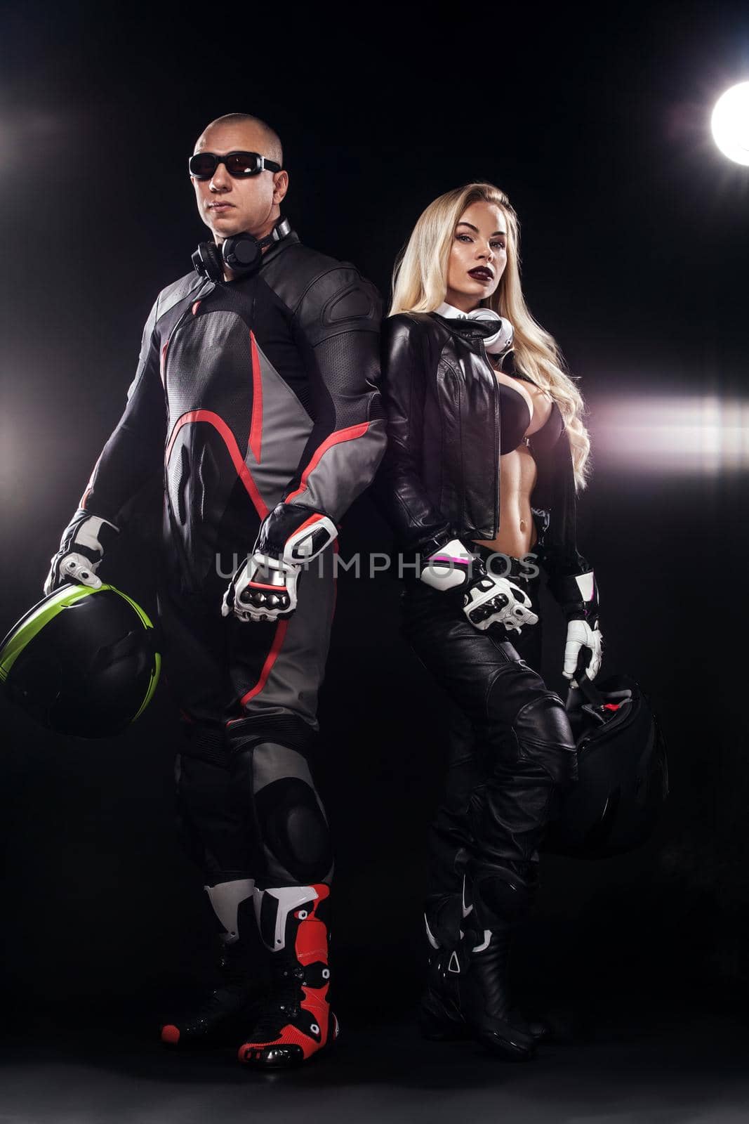 Fashion couple model DJ and biker with headphones and sunglasses, black leather jacket, leather pants, stylish pretty blonde woman and man in night casual outfit. Long wavy hairstyle. by MikeOrlov