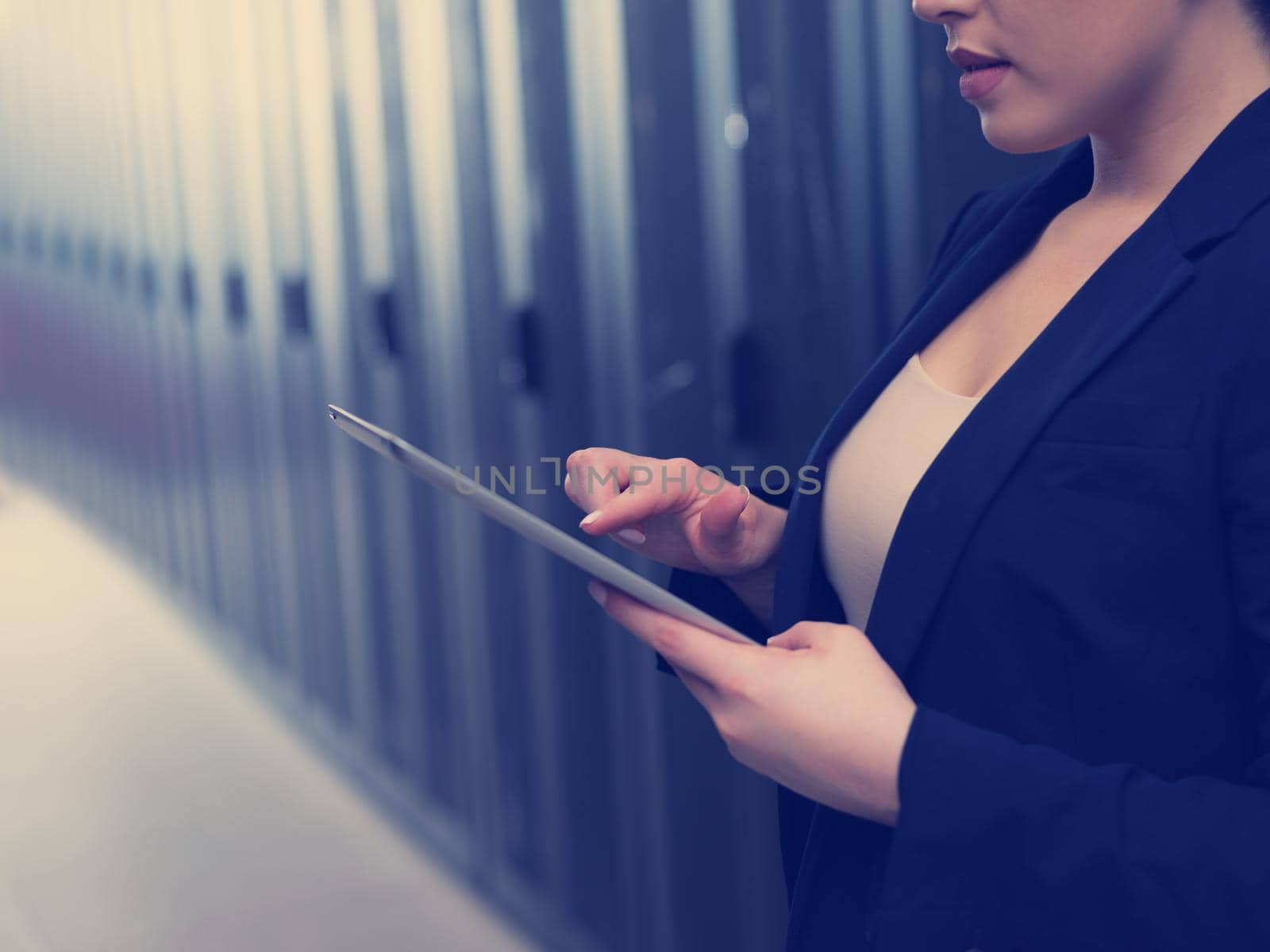 Female engineer working on a tablet computer in server room by dotshock