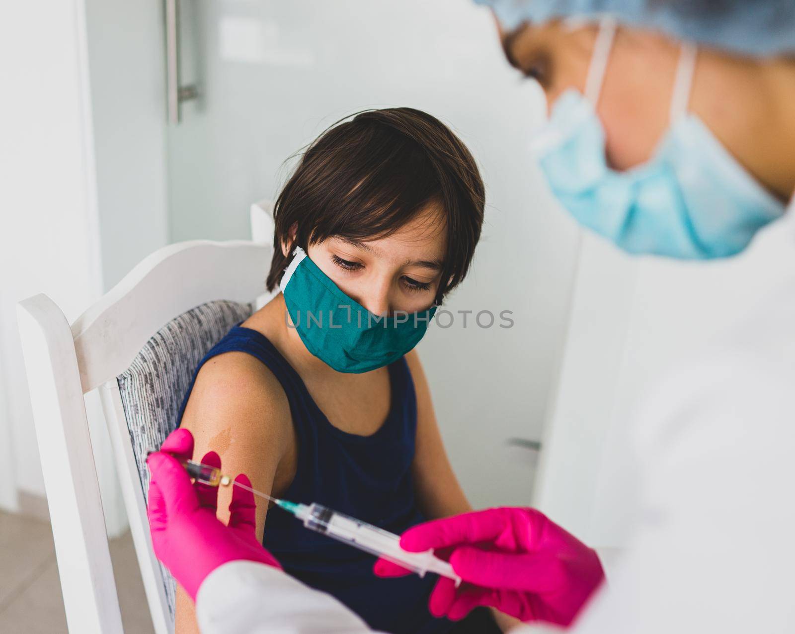 Little cute child with mask getting injection