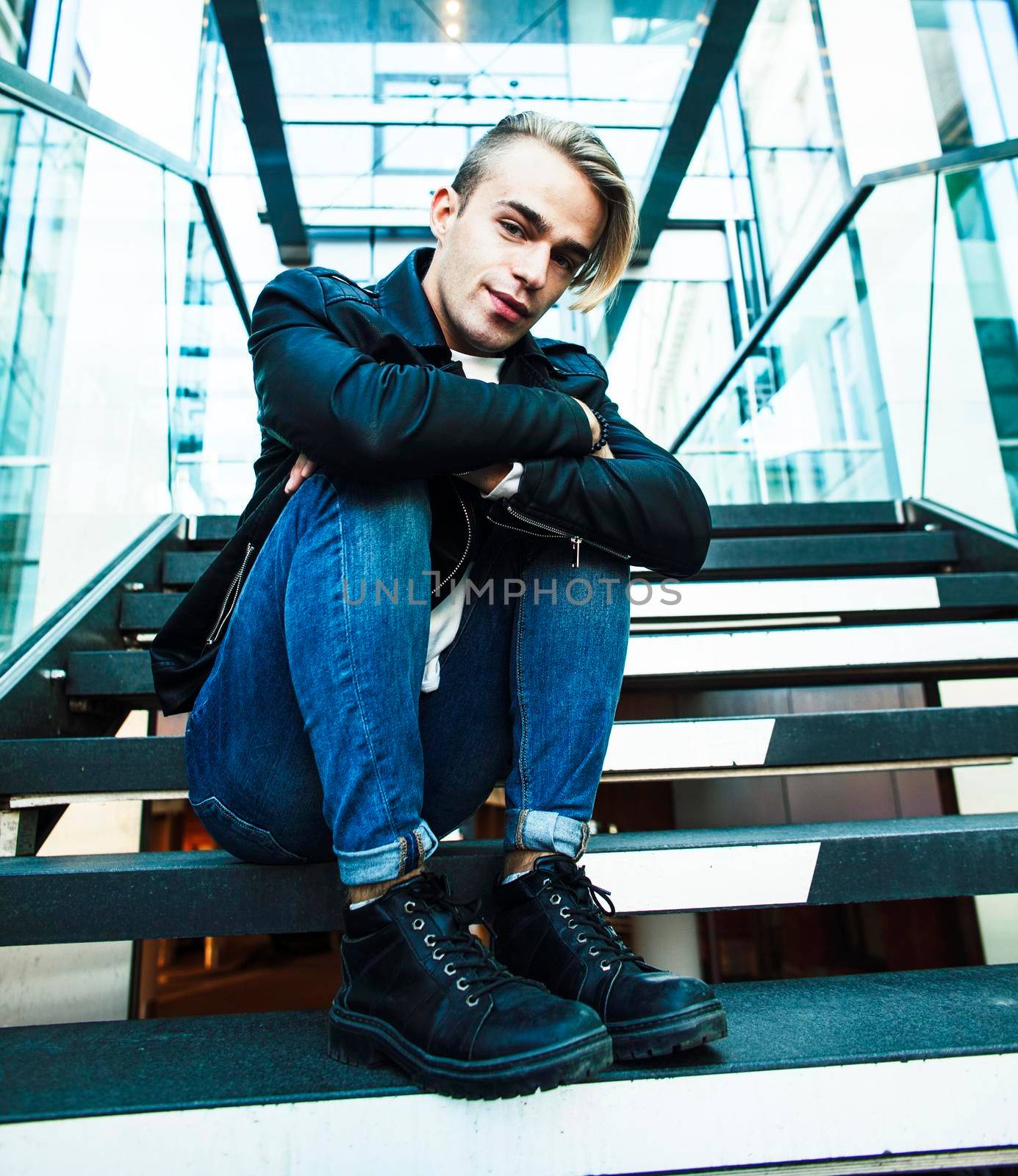 young modern hipster guy at new building university blond fashion handsome boy, lifestyle people concept closeup