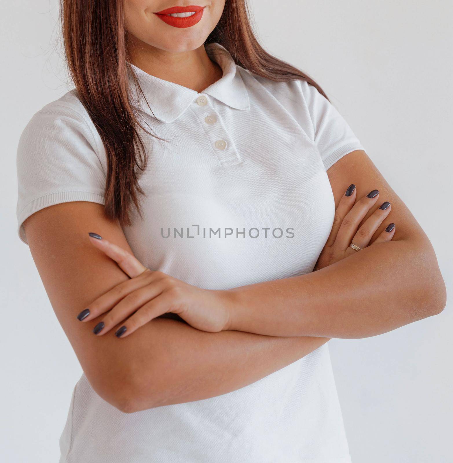 Business woman portrait. Arms crossed. Woman in a white T-shirt on a white background, red. Corporate concept.