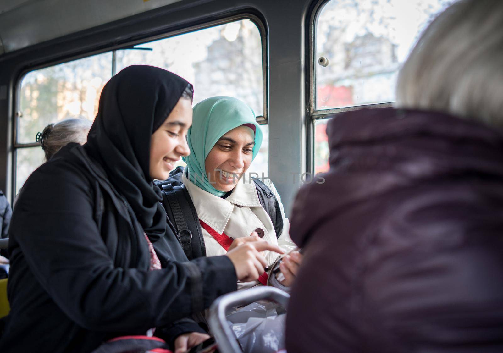 Mother and daughter riding public transport in city by Zurijeta