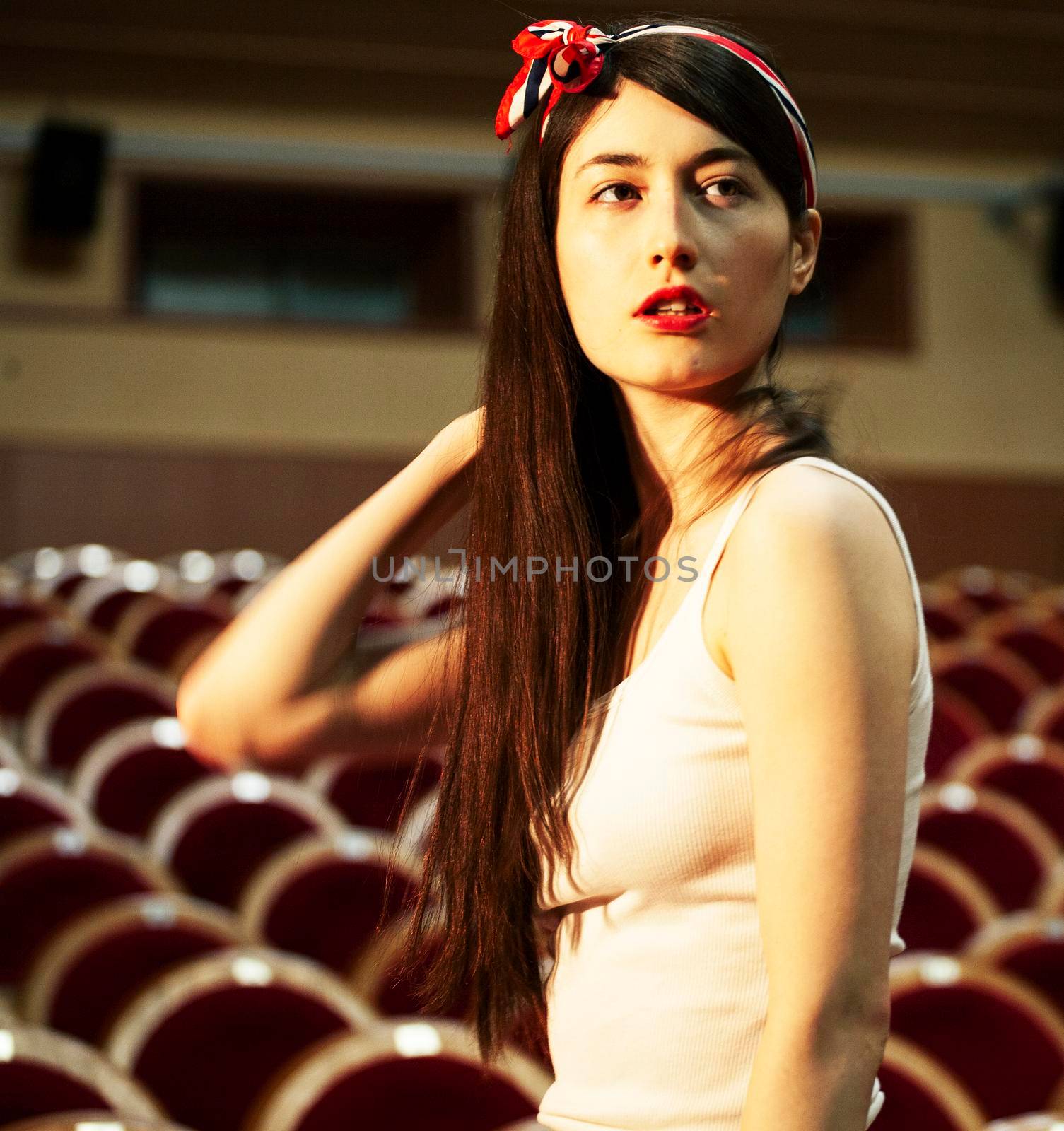 portrait of a pretty girl hipster in a movie theater wearing hat, dreaming alone, fashion lufestyle people concept by JordanJ