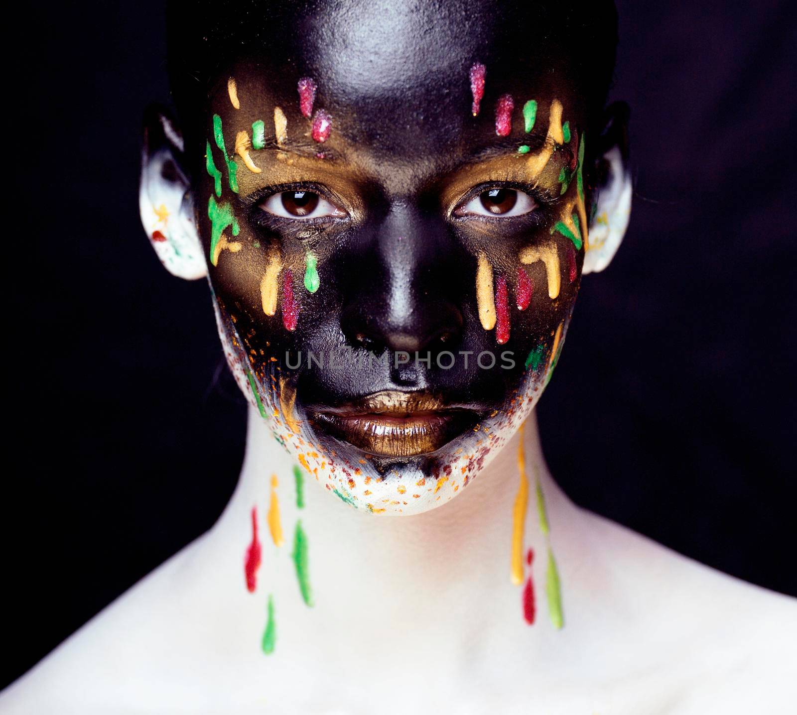 woman with creative makeup closeup like drops of colors, facepaint splashes close up halloween