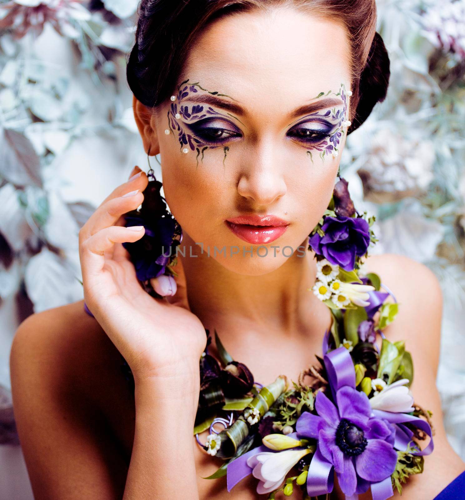 floral face art with anemone in jewelry, sensual young brunette woman in studio close up by JordanJ
