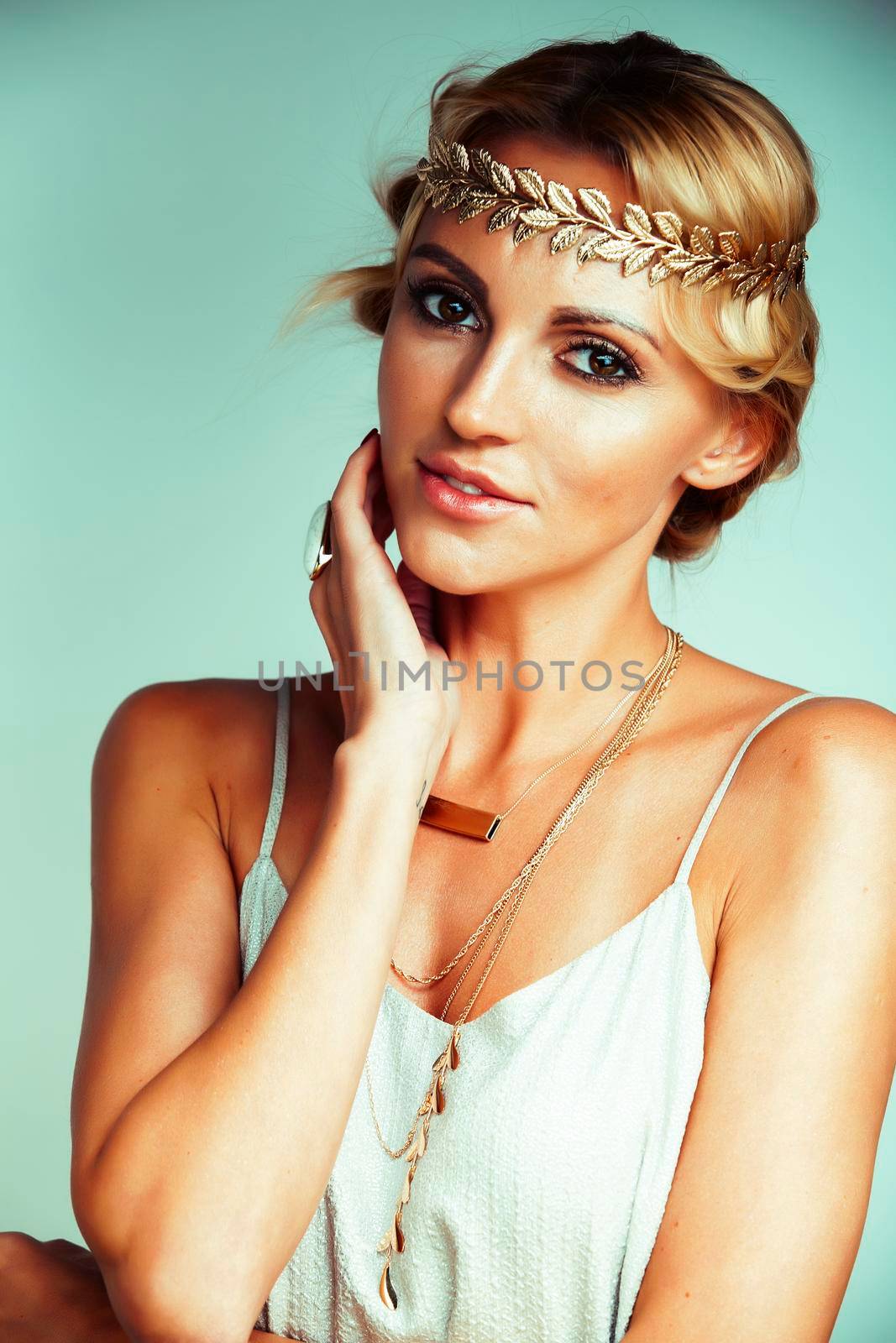 young blond woman dressed like ancient greek godess, gold jewelry closeup isolated, beautiful girl hands manicured red nails