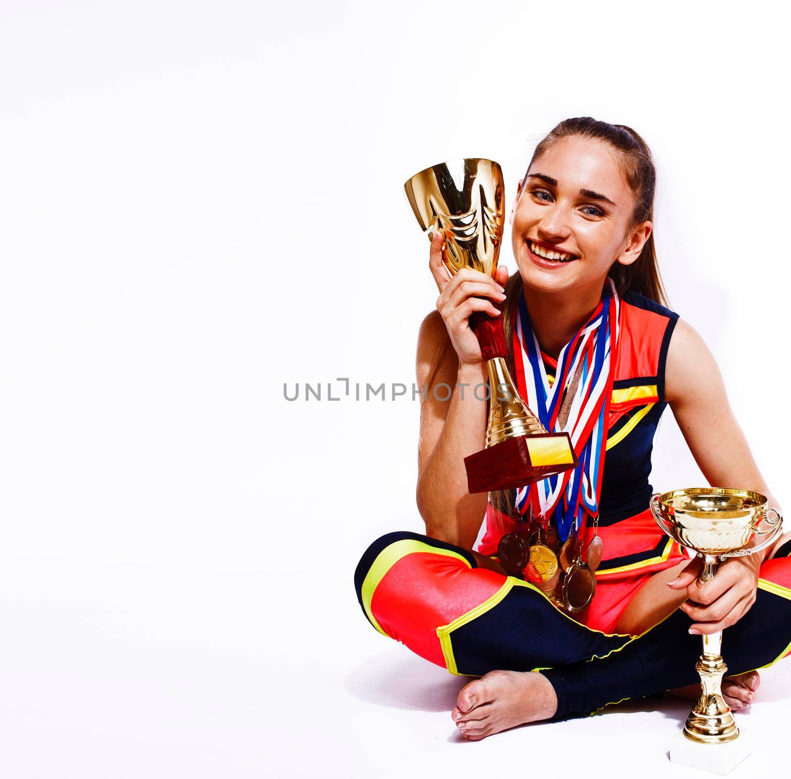 young smiling cheerleader girl with golden cups and price medals isolated on white background, lifestyle sport people concept close up