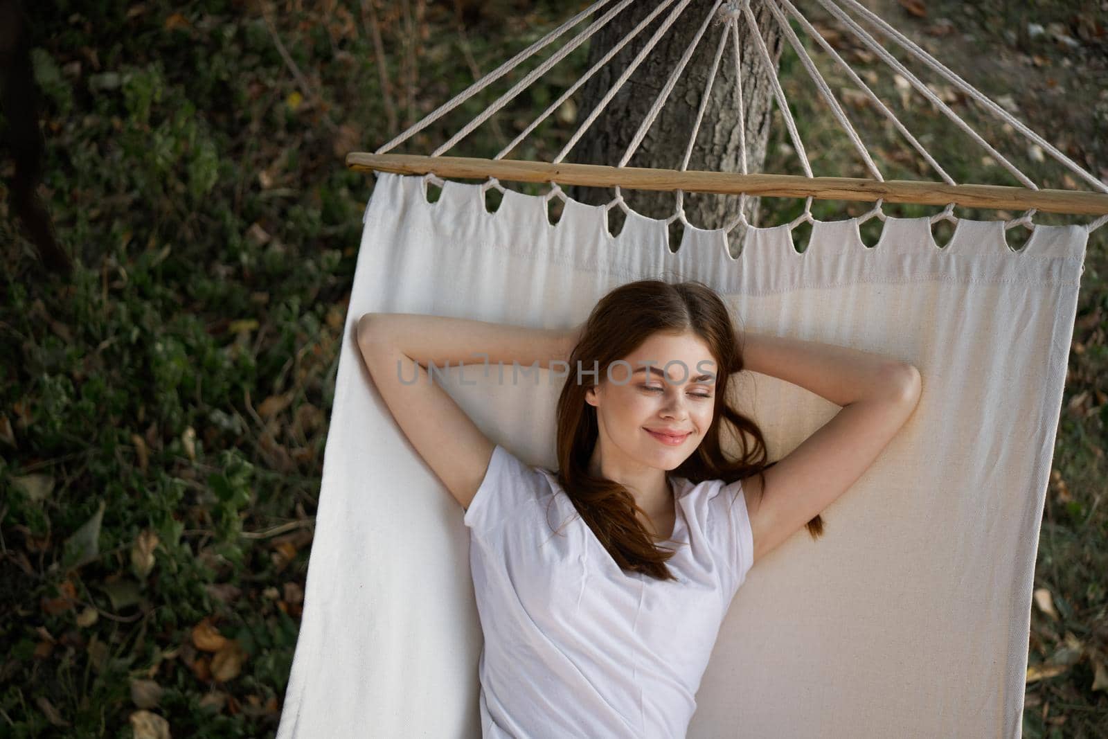 cheerful woman lies in a hammock outdoors nature vacation summer by Vichizh