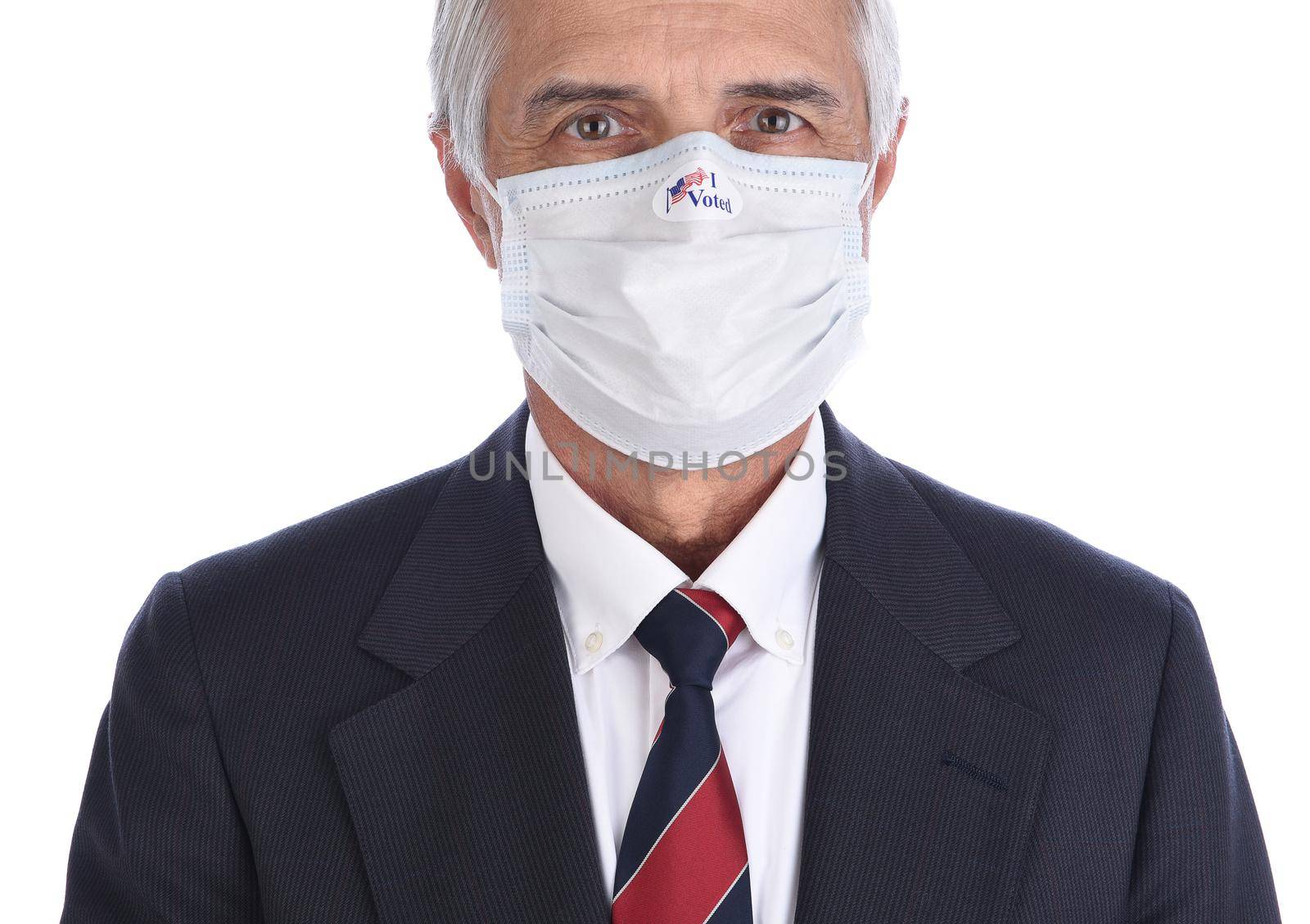 Closeup of a businessman with an I Voted sticker on the COVID-19 protective mask he wore to vote.
