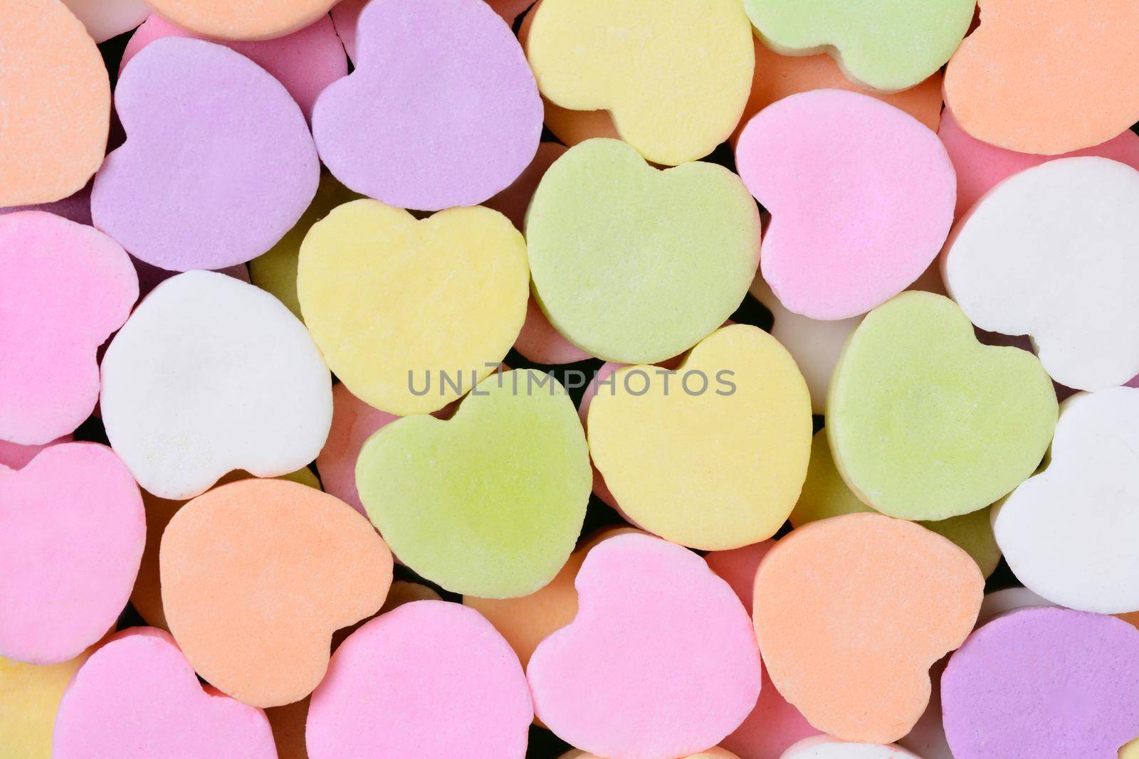 Macro shot of pastel candy hearts for Valentine's Day. The hearts are all bland and ready for your message.