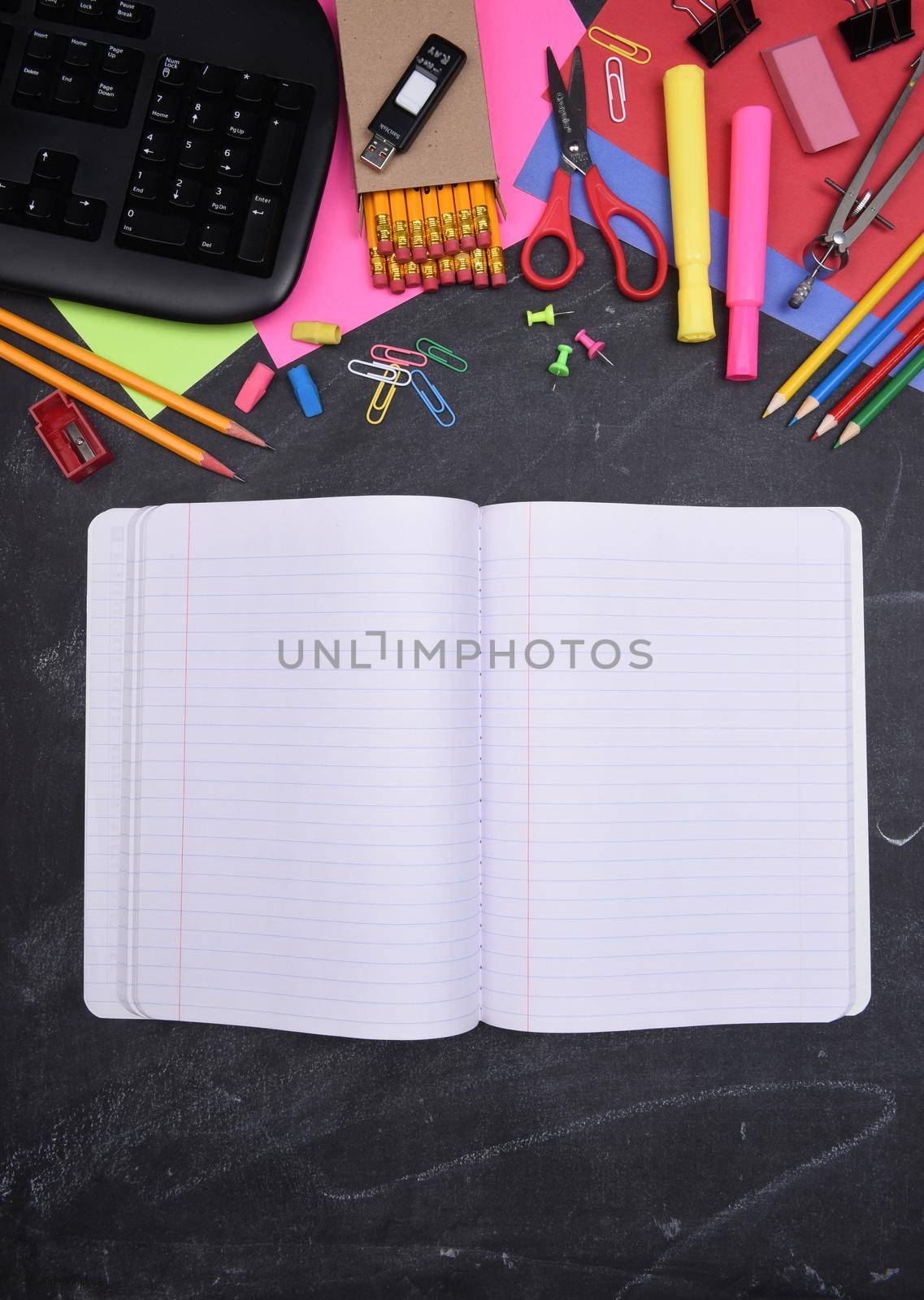 School Supplies: Still life on erased Chalkboard with open notebook and copy space.