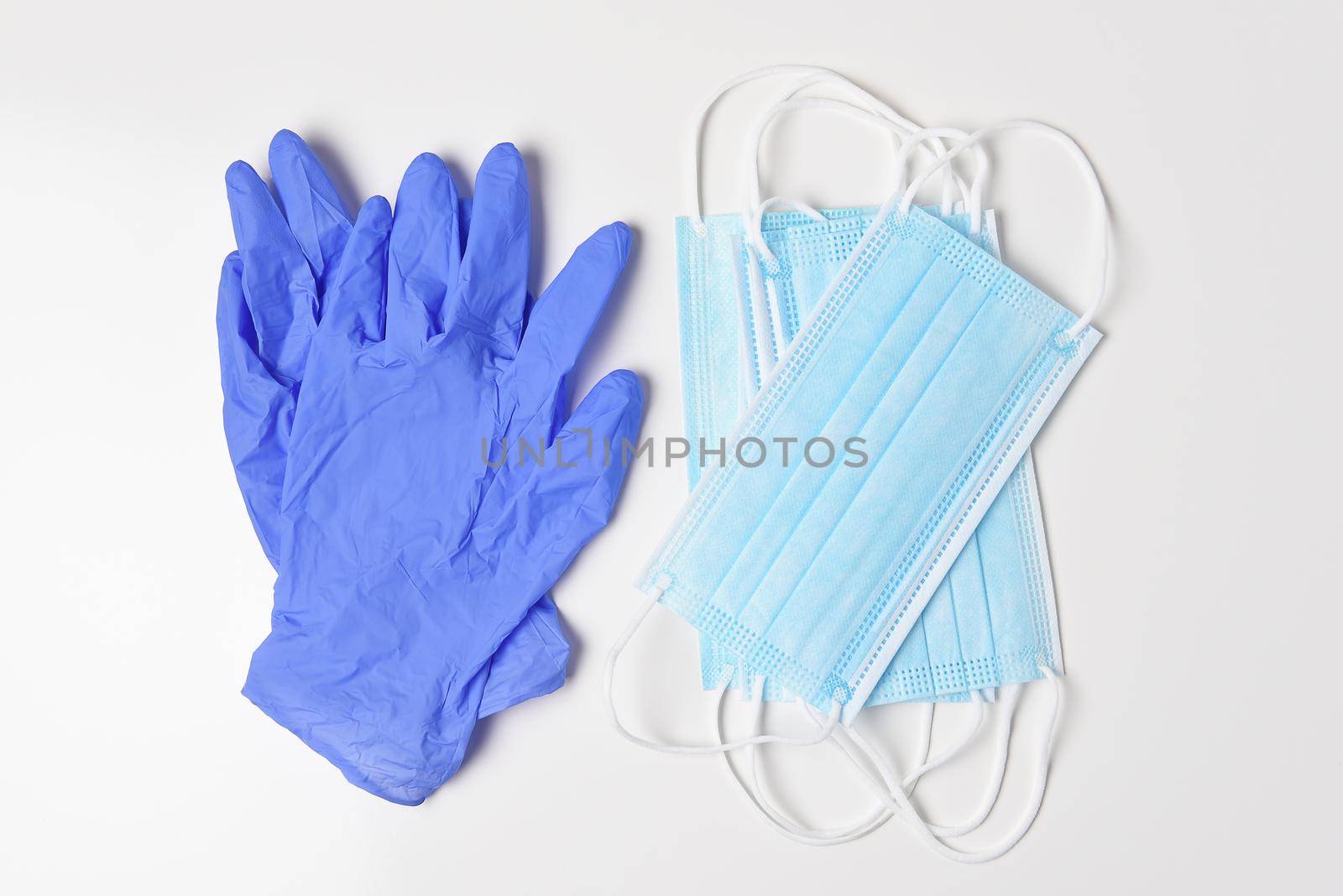 A group of medical masks and lates gloves on white, High angle shot.