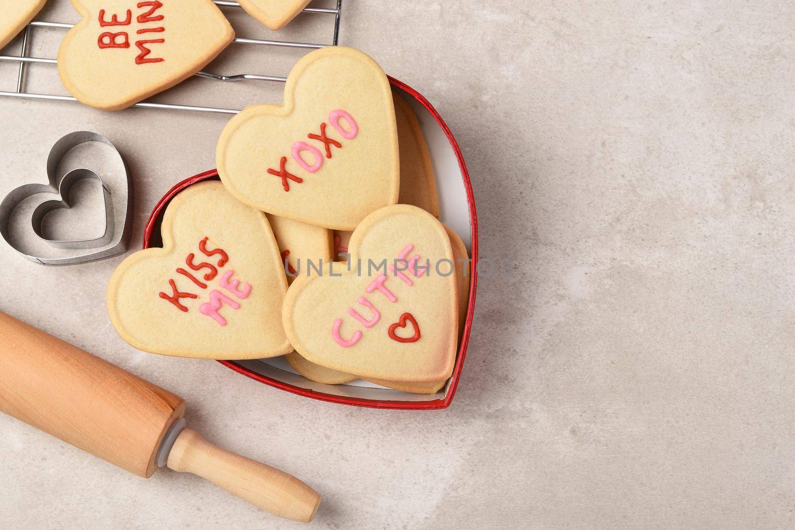 Valentines Day Concept: Heart shaped sugar cookies in a heart shaped box with cooling rack and rolling pin, with copy space.