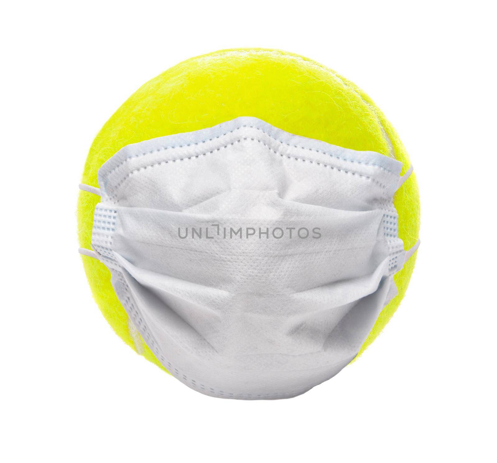 Covid-19 and Sports Concept. A tennis ball with Surgical Mask, isolated on white.
