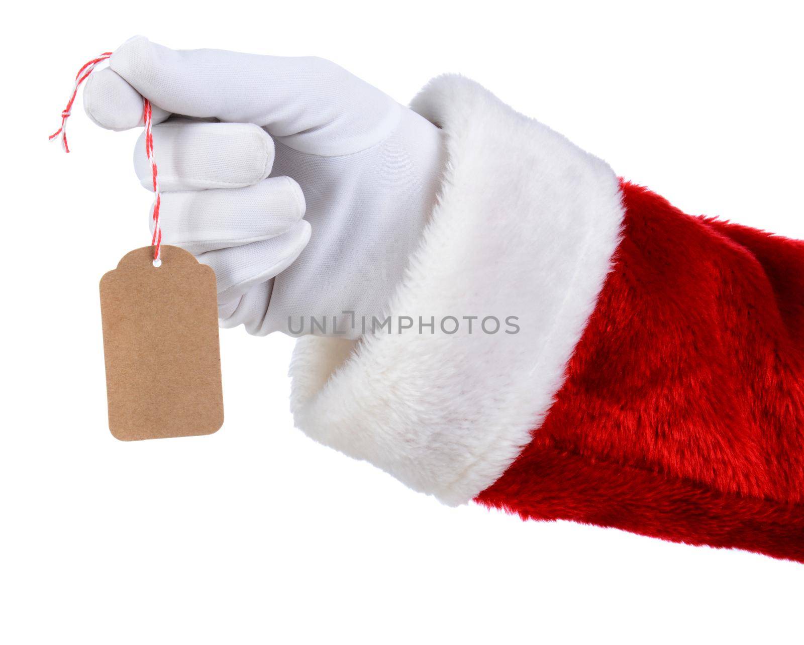 Closeup of Santa Claus hand holding a blank gift tag over a white background. Only Santa's white gloved hand red suit are shown.
