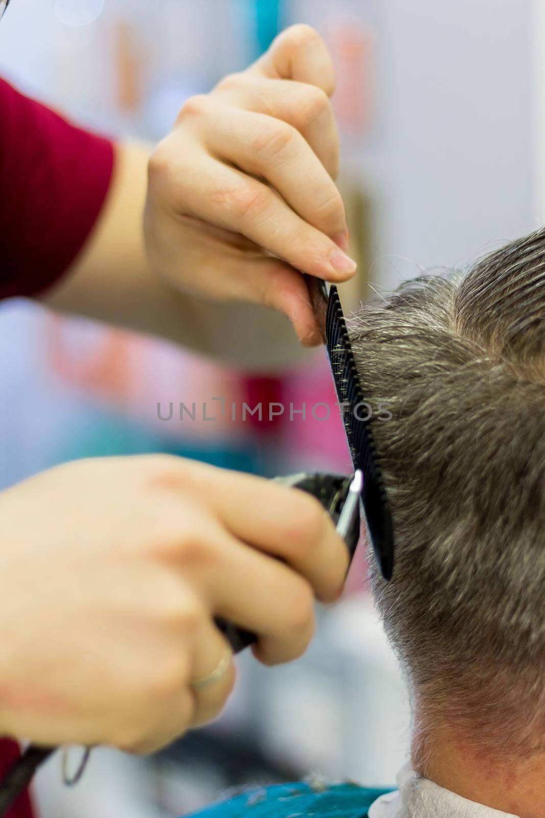 The hairdresser cuts the man's hair with a clipper and comb. Short men's haircut. Close-up.