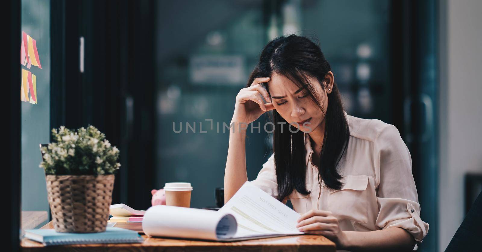 Tired young asian woman feel headache from working problem. Stressed female suffer from headache bad vision sight problem sit at workplace