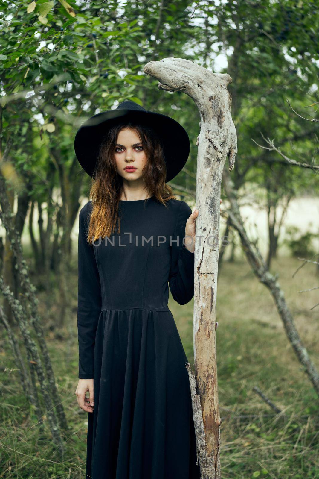 woman in black suit Witch in a fantasy forest. High quality photo