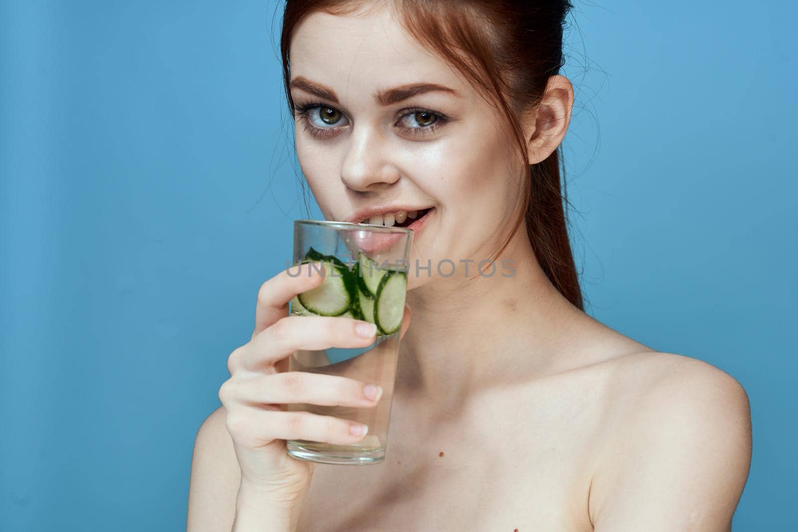 woman with bared shoulders cucumber health drink blue background by Vichizh