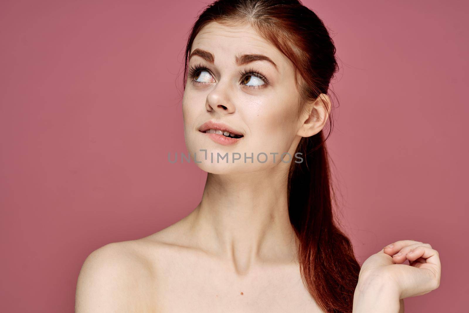 cheerful woman with bare shoulders posing clear skin pink background by Vichizh