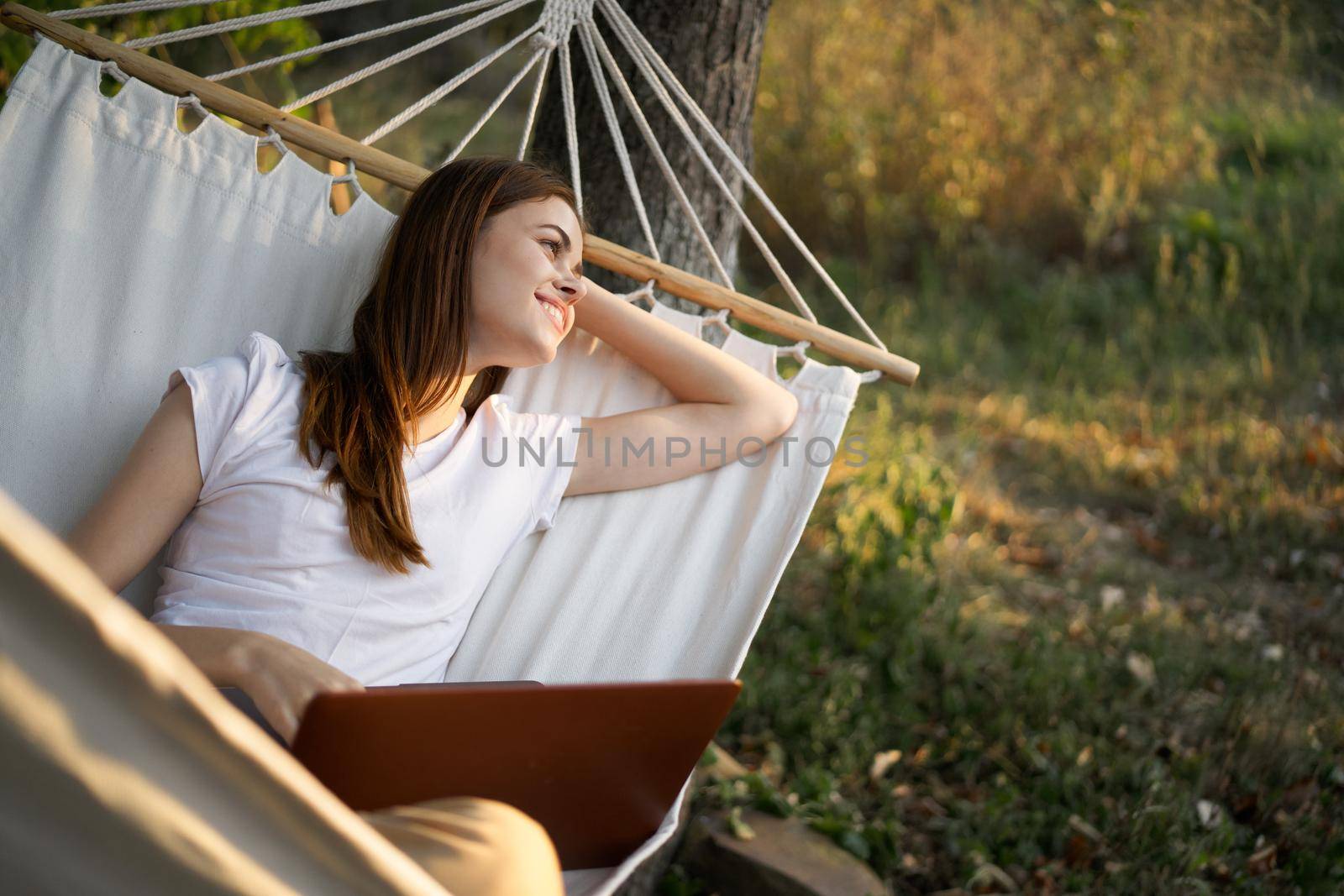 woman with laptop and lies in a hammock vacation nature freelance. High quality photo