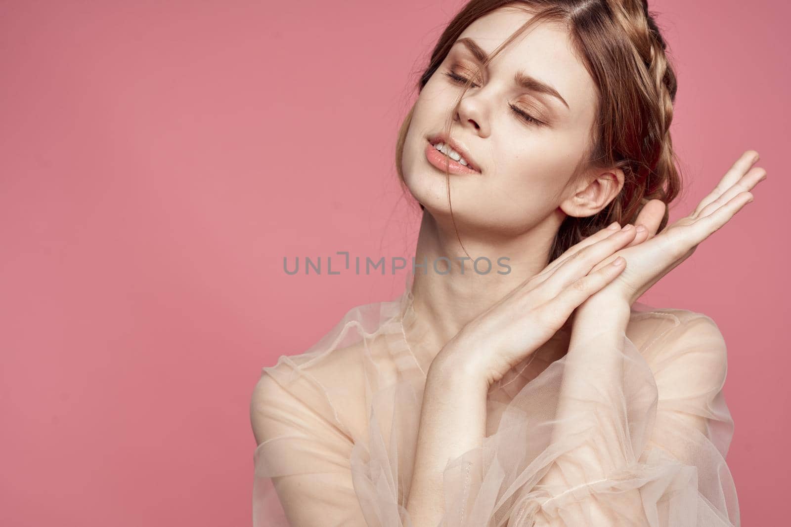 beautiful woman gesture hands cosmetics fashion hairstyle posing pink background. High quality photo