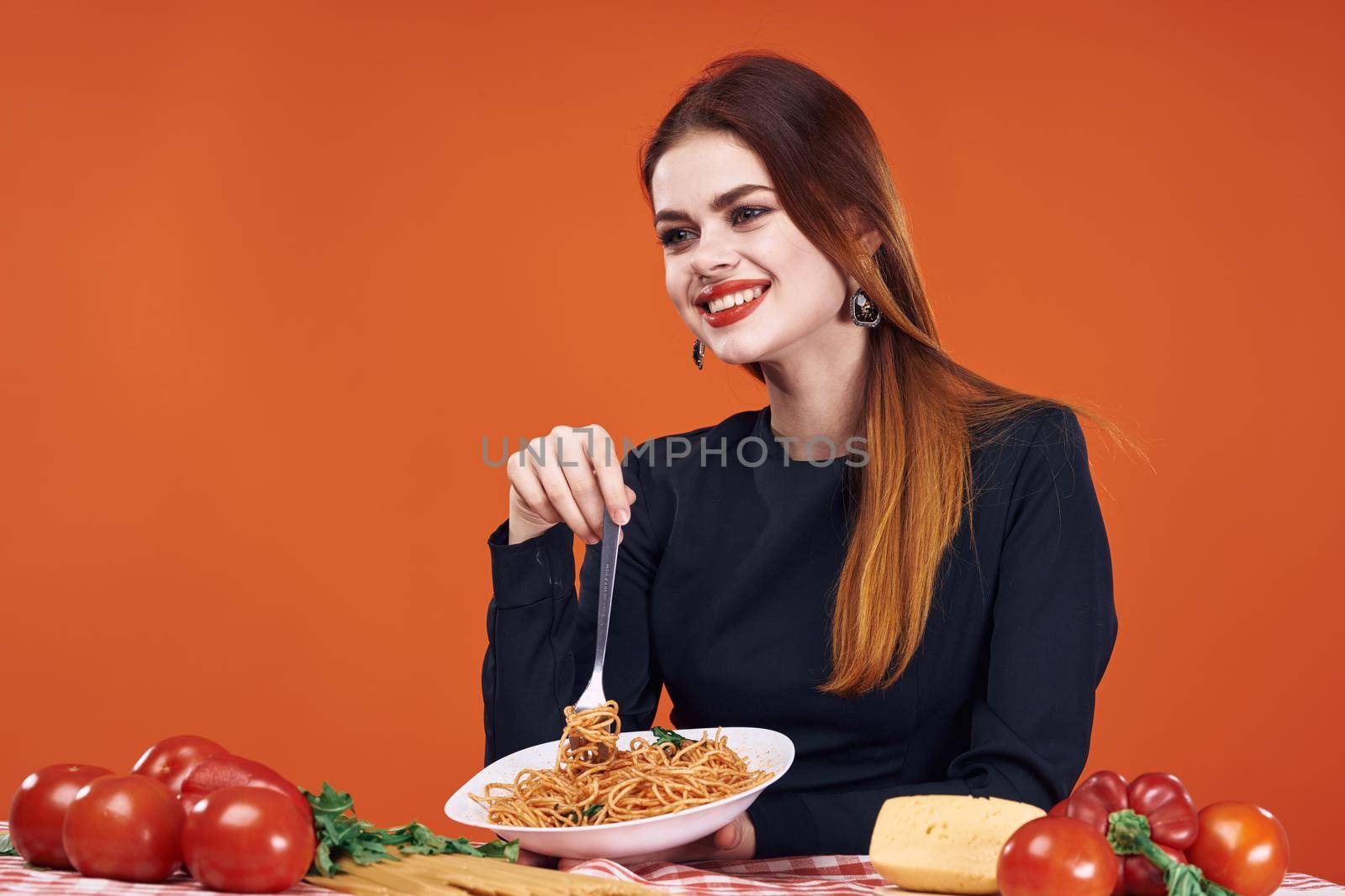 woman sitting at the table with food eating spaghetti. High quality photo